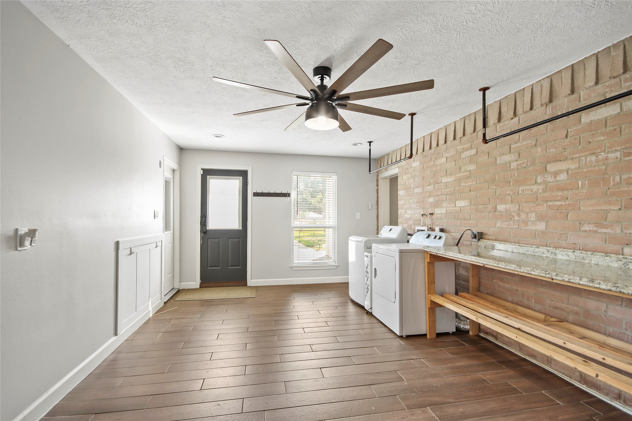 The spacious utility room offers room for a washer and dryer, plus a built-in folding counter and extra storage.