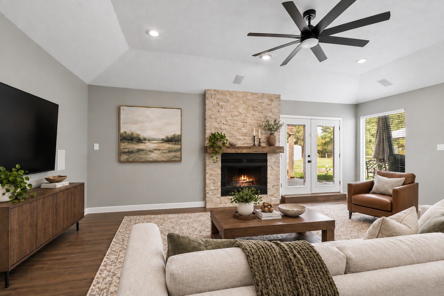 The living area is anchored by a stunning stone fireplace with a wood mantel, framed by vaulted ceilings and French doors that bring in plenty of natural light. Virtually staged. The living area is anchored by a stunning stone fireplace with a wood mantel, framed by vaulted ceilings and French doors that bring in plenty of natural light. Virtually staged.