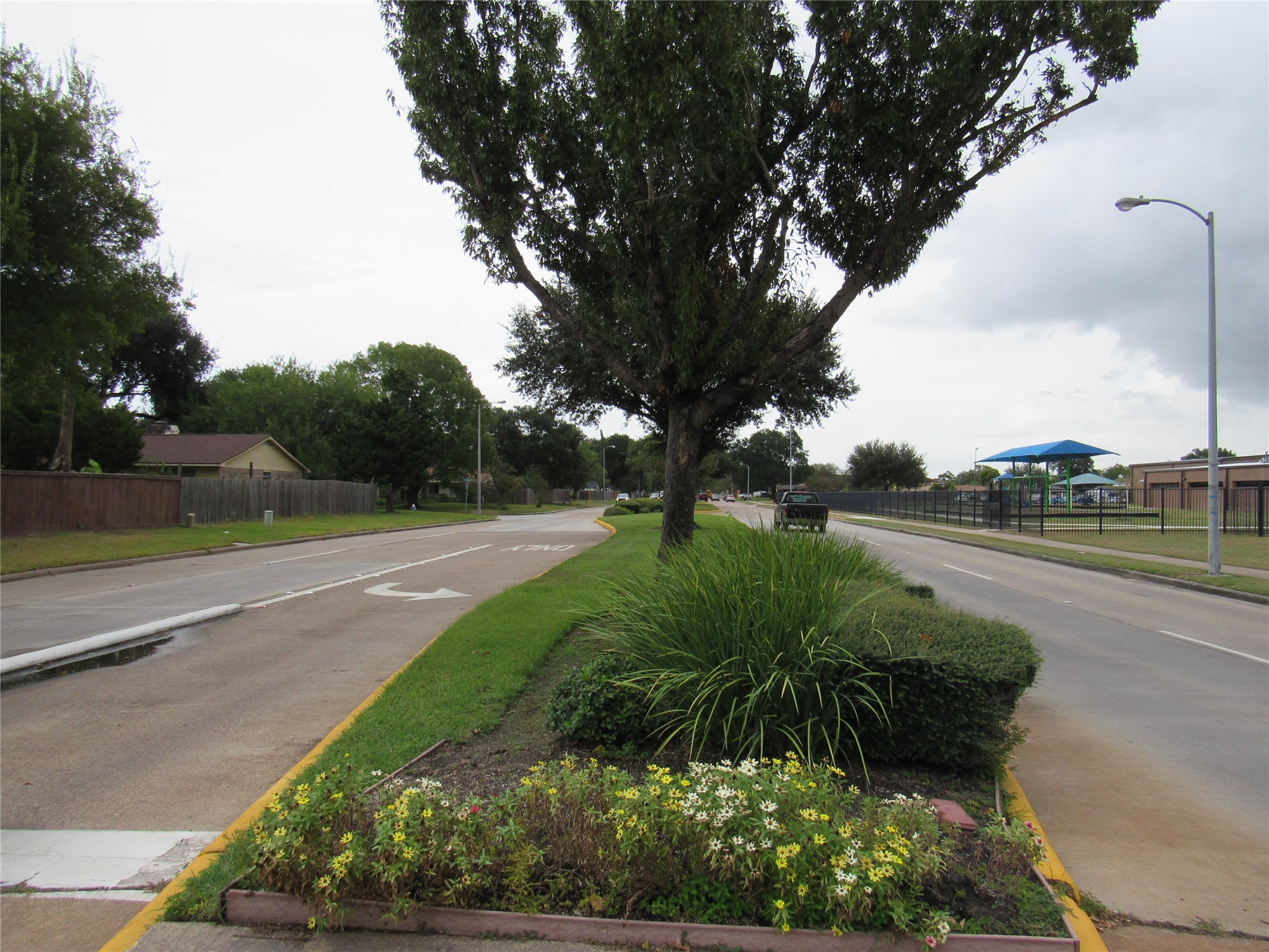 Divided and landscapped 4=lane West Road (main road) with side walks.
