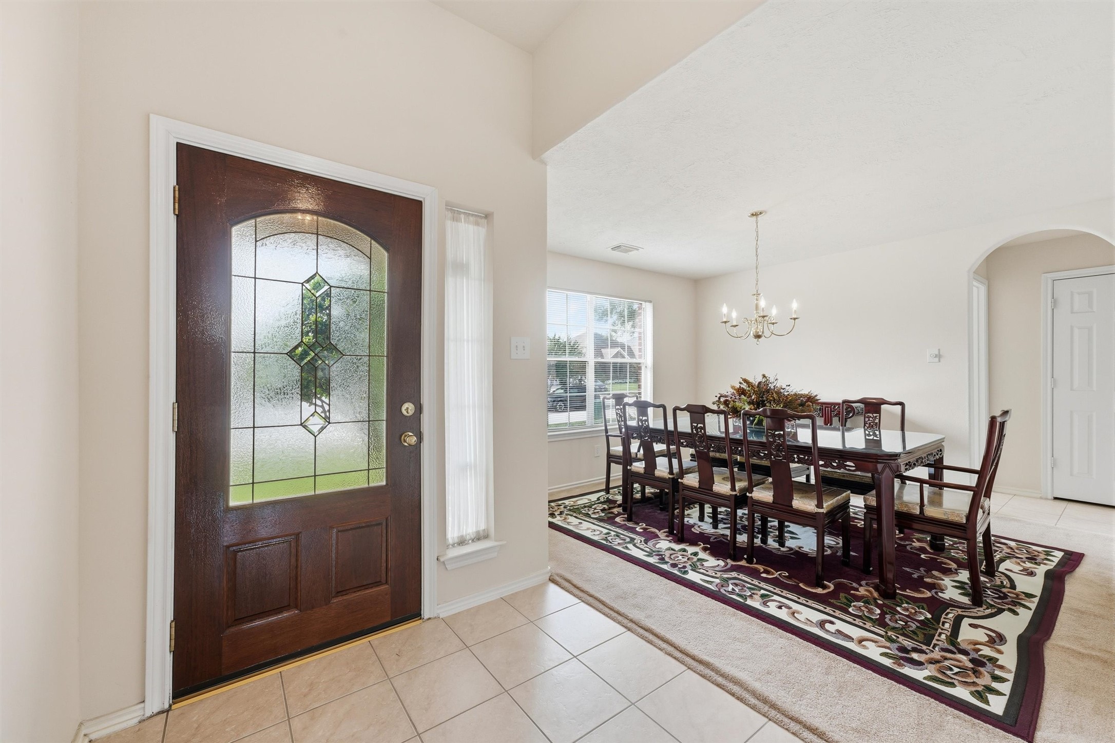 Step through the elegant front door into a bright, inviting formal dining room perfect for entertaining.