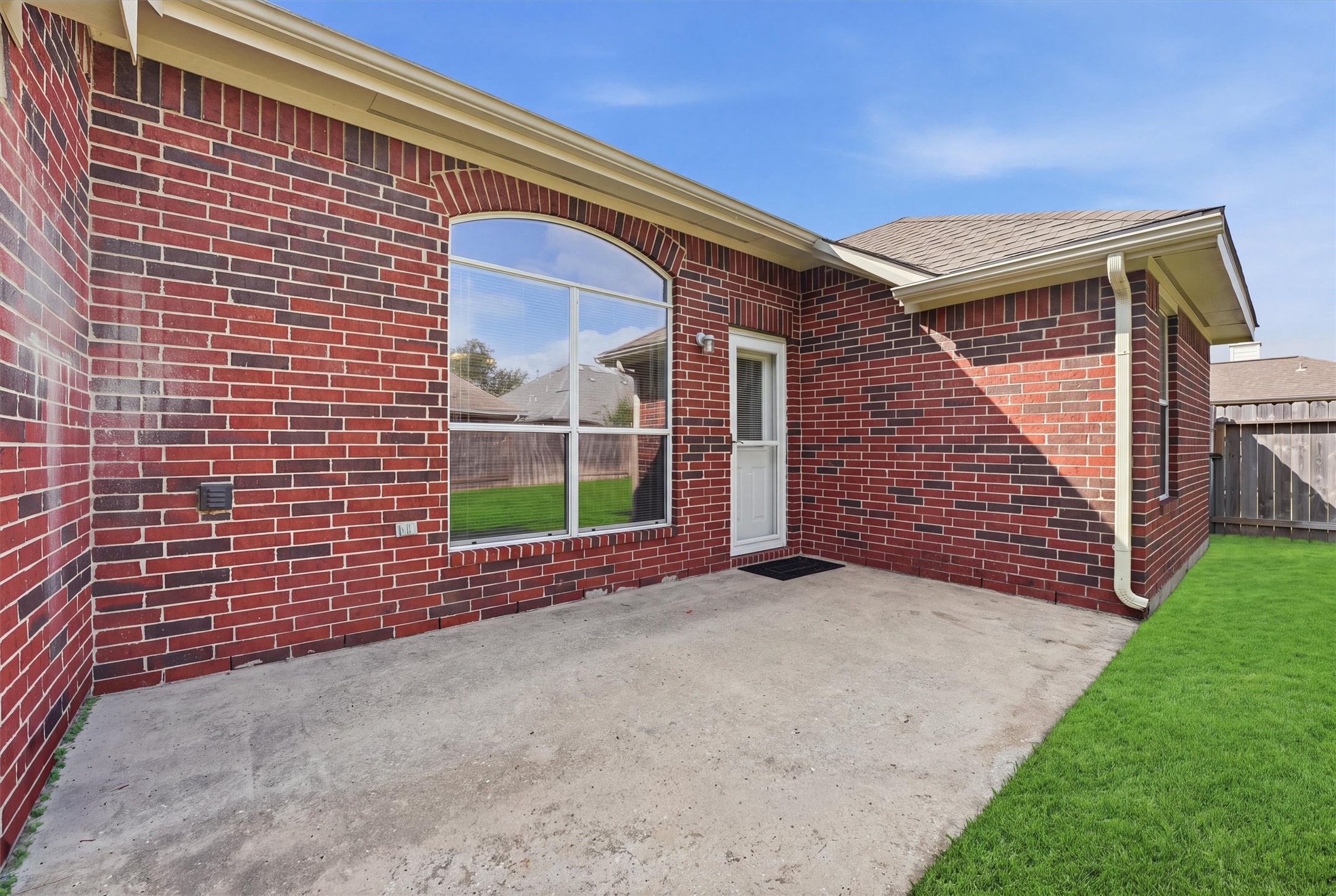 Charming red brick exterior with a spacious patio area, perfect for outdoor relaxation and entertaining.