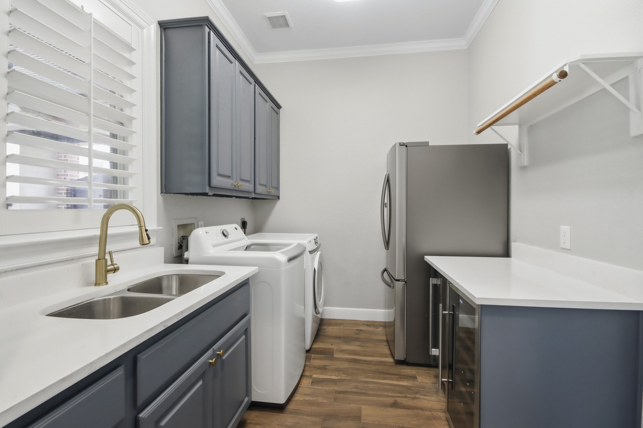 Stylish and functional, this laundry room features modern cabinetry, modern appliances, and ample counter space for efficient and enjoyable laundry days.