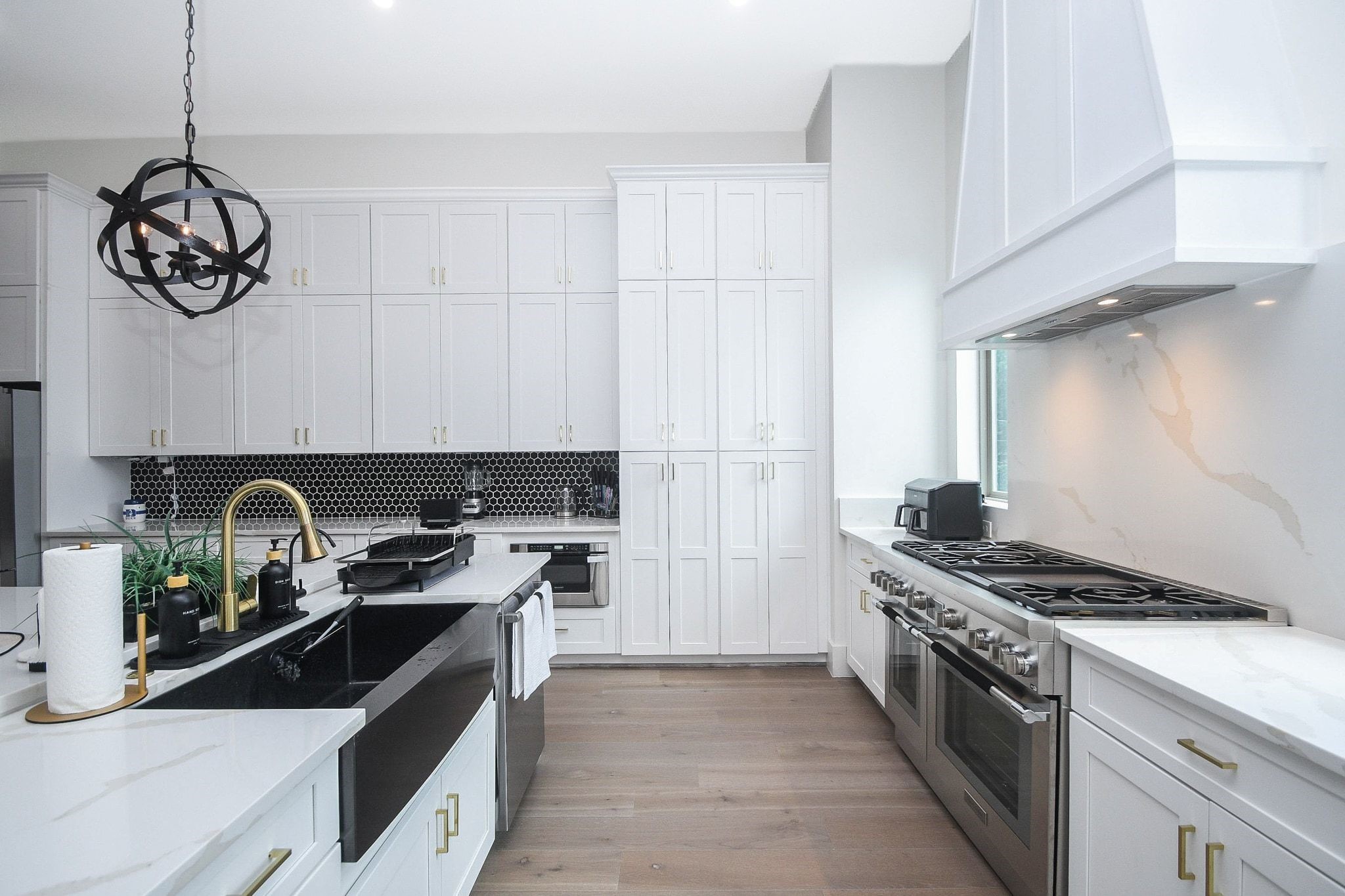 Tasking, prepping and serving are nicely accomplished in this state-of-the-art modern kitchen with room for every crucial appliance and kitchen gadget! Note the dark farmhouse style sink, with front apron. Stunning!