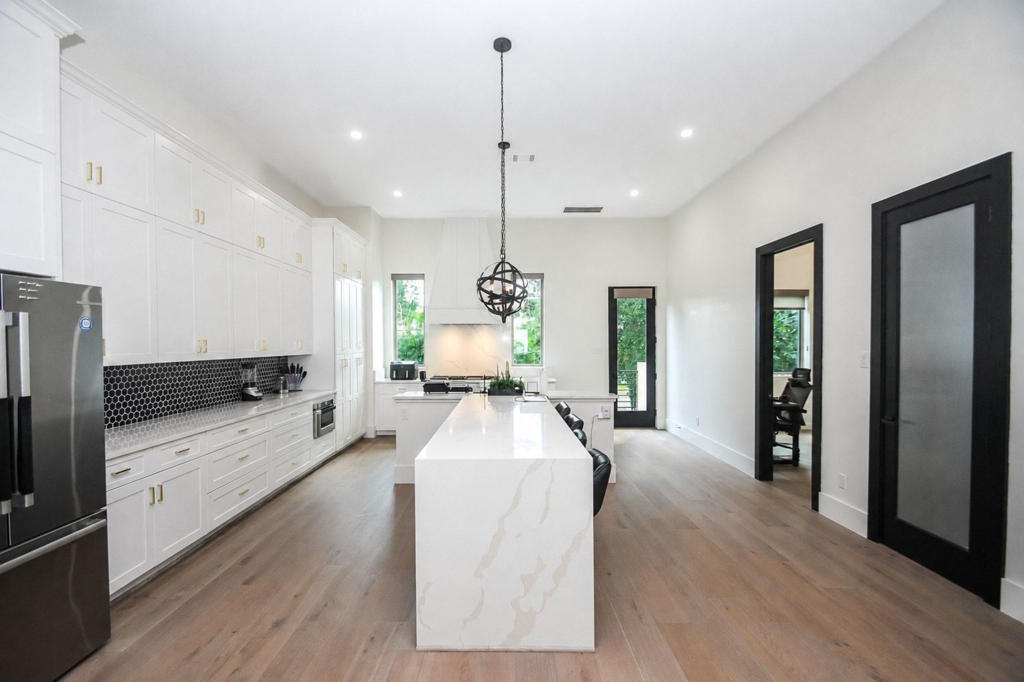 Whoever thought that a huge center island --- in the middle of a kitchen --- would make your footing and tasking easier? Well, for years we've known that this designated feature is a blessing and luxurious convenience for any home cook! Streamlined storage, up and down, keeps items within reach and uncluttered when the long Carrara Gold Quartz wall counter (left) and island counter, is yours to conquer!