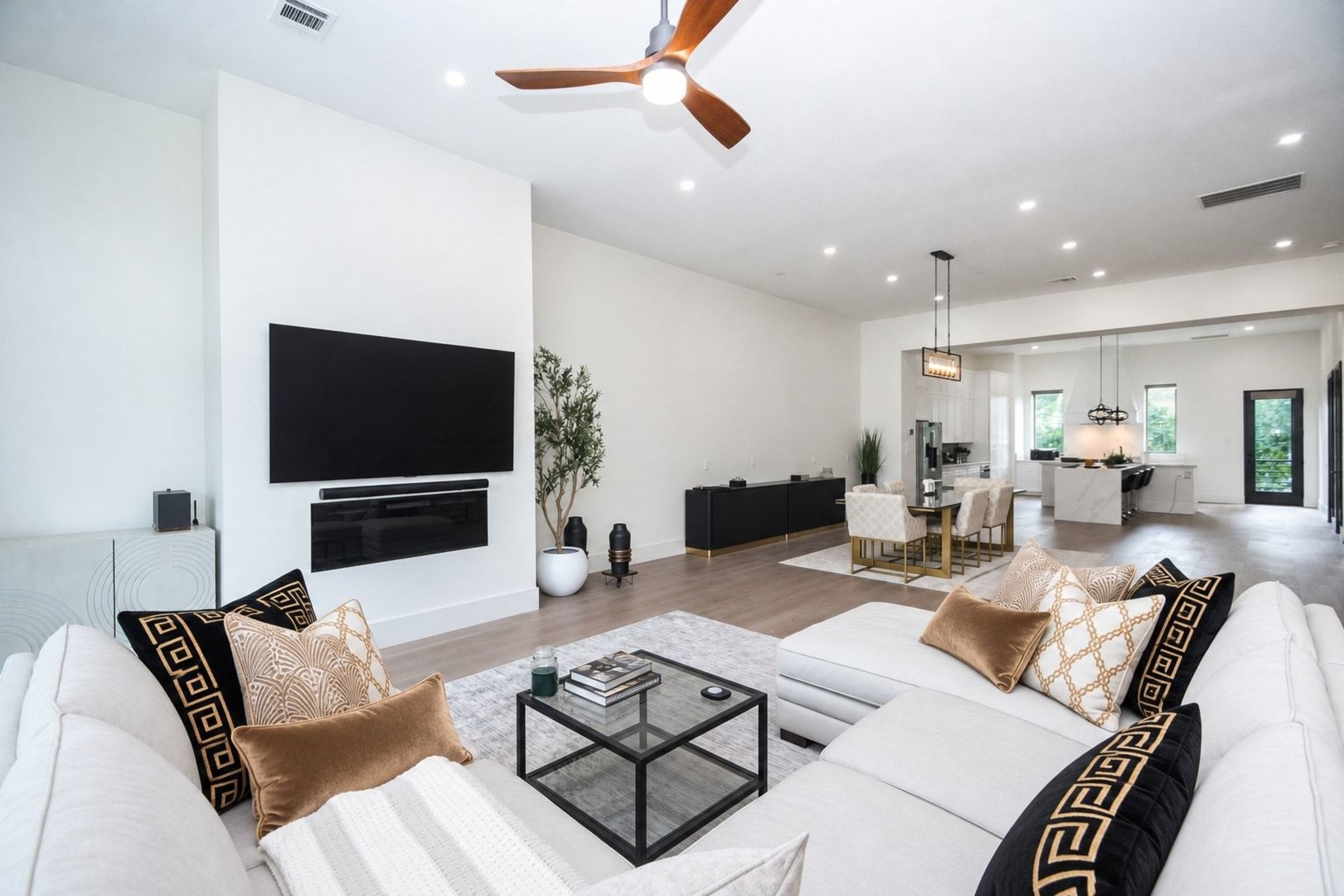 As suggested in this view, the adage 'less is more' perfectly applies, with sleeks lines comprising wall/floor space, sophisticated recessed ceiling lighting, modern pendant lighting over the dining area, up right center, with comfortable, open access to the kitchen beyond.