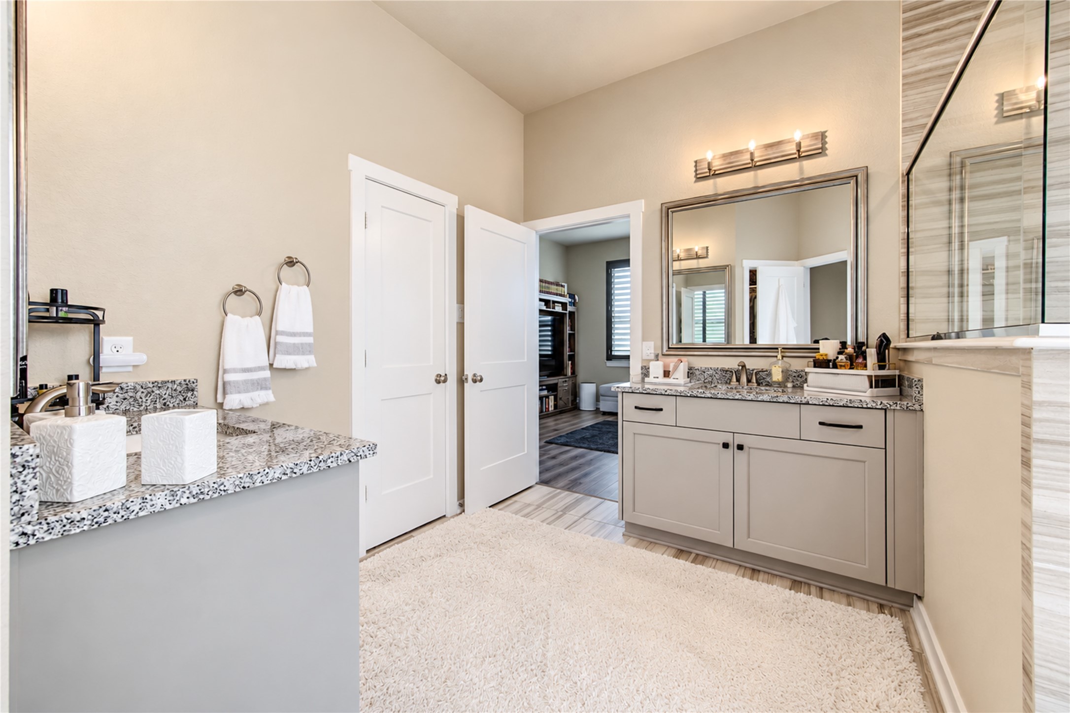 The primary bathroom offers generous counter space, separate vanities and attractive finishes throughout.