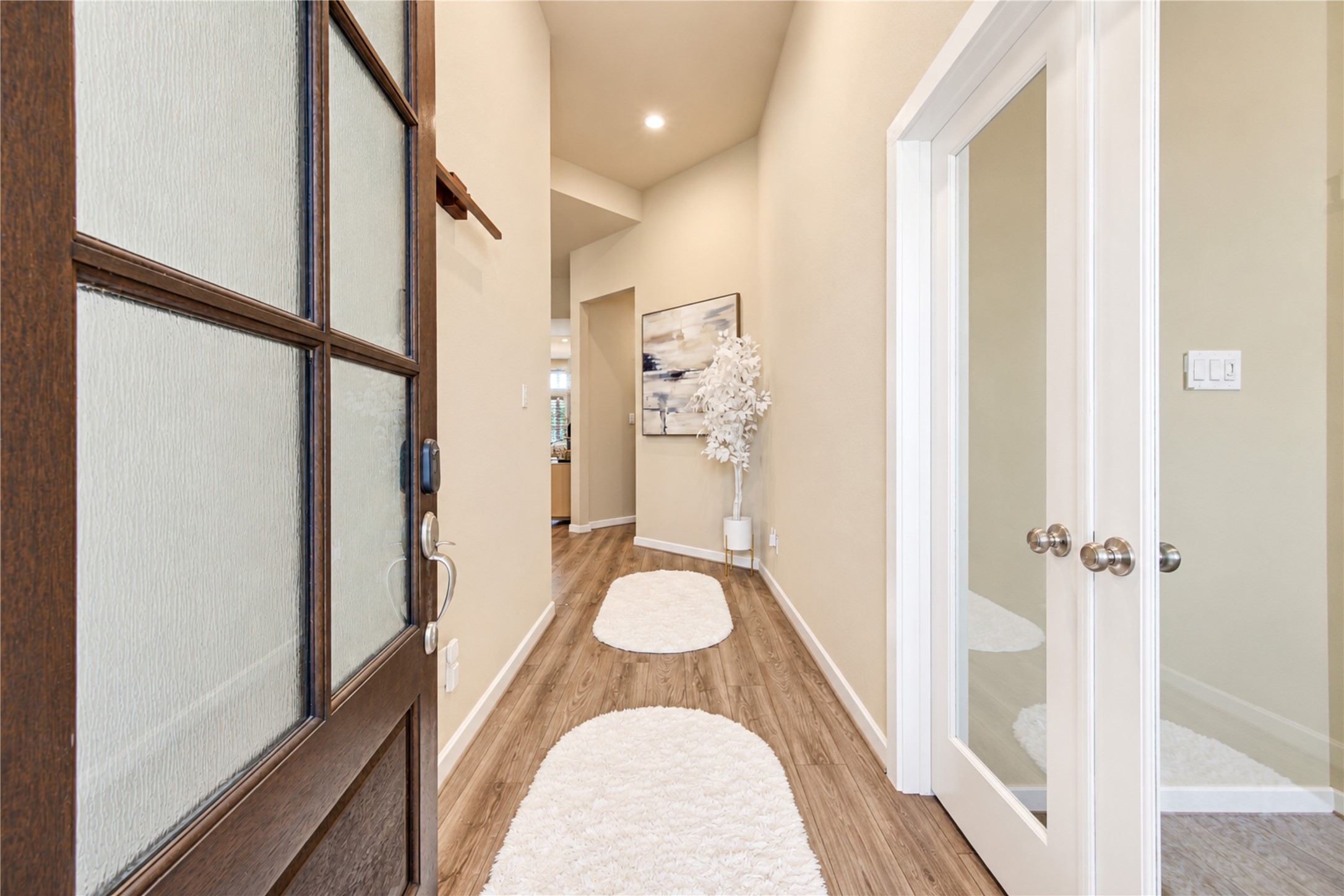 A welcoming entry with high ceilings, wood-look tile flooring and a private office just off the foyer.
