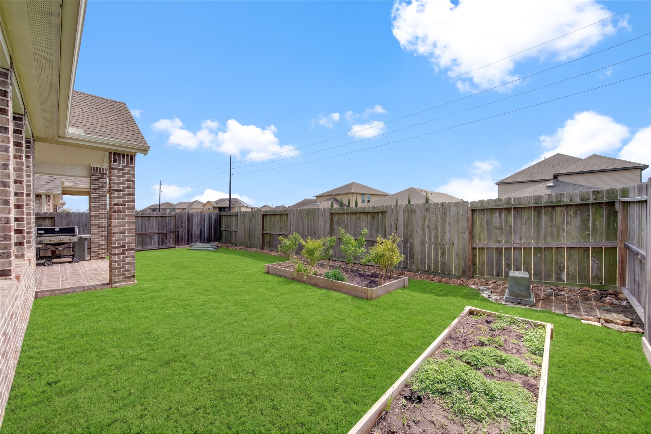Another look at the backyard, offering open green space and a covered outdoor area.