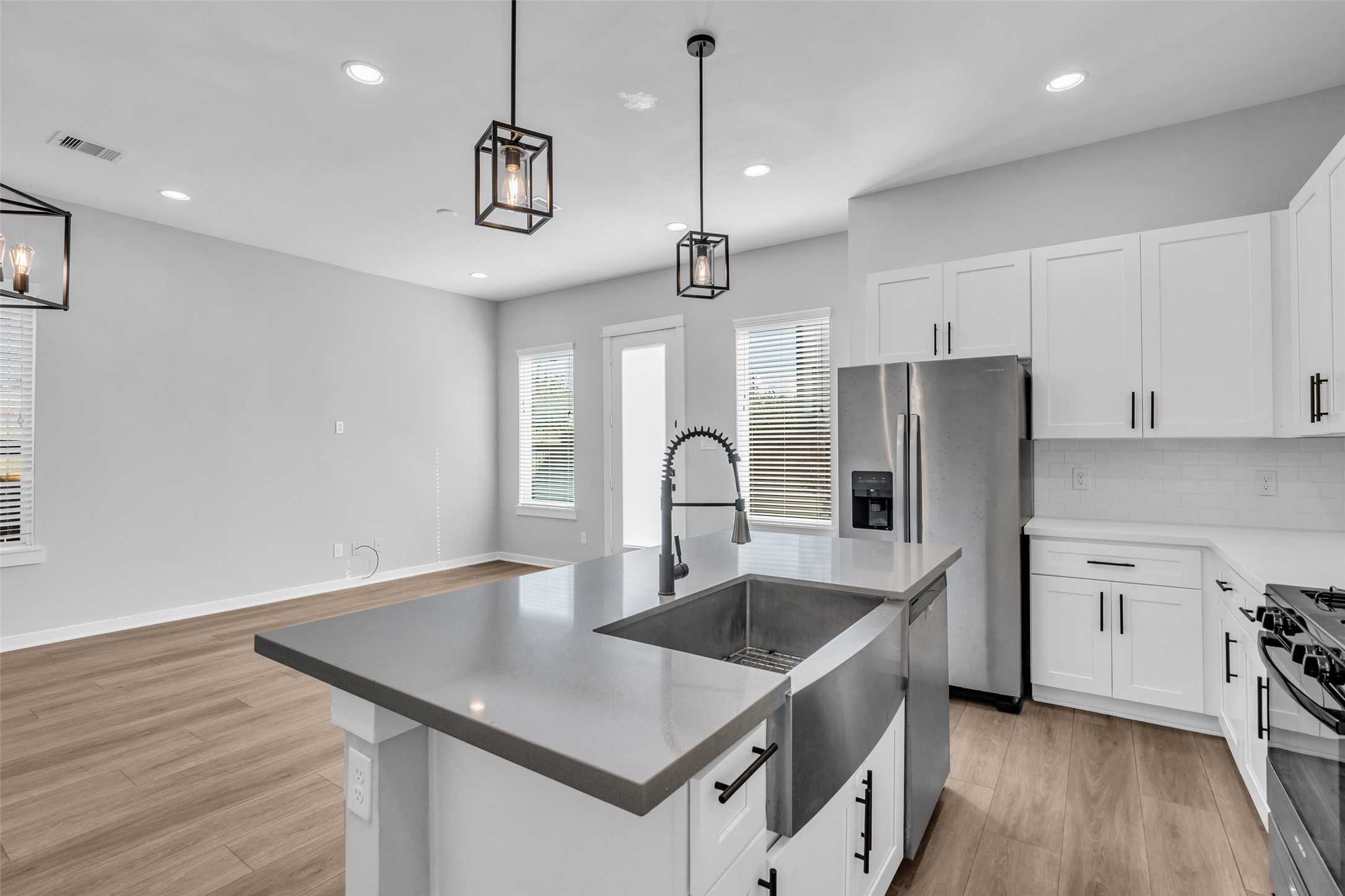 The farmhouse sink looks out across the dining area to the backyard door, easy for entertaining indoors and out.