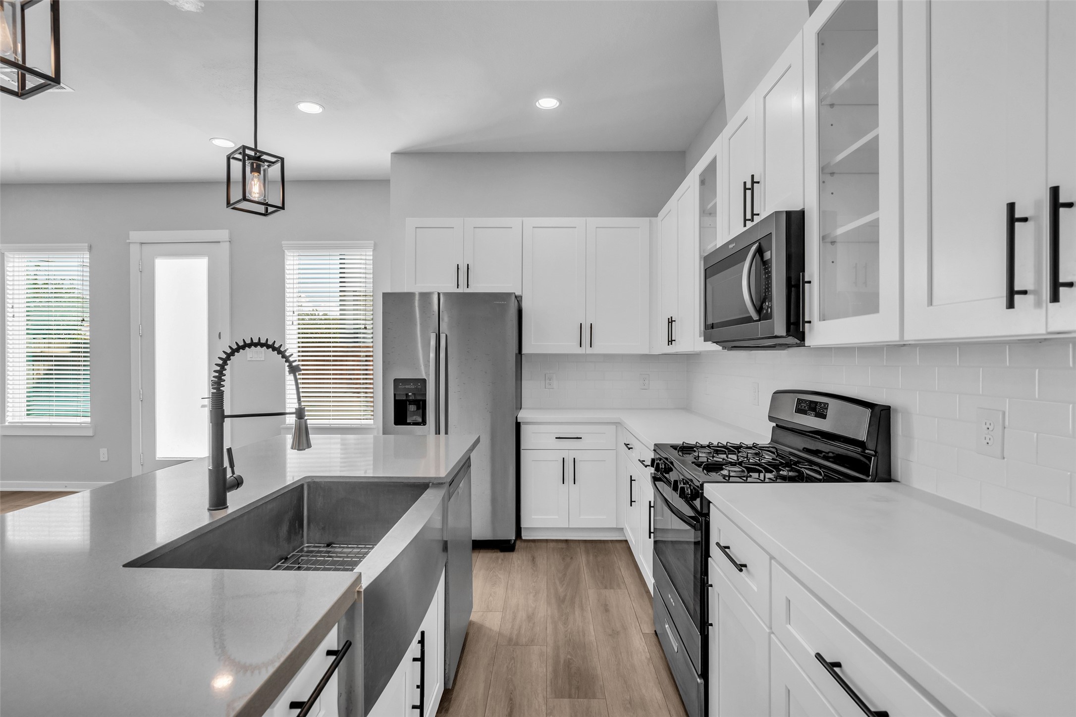 Details that make everyday cooking easier: a deep farmhouse sink, pull-down faucet and subway tile backsplash.