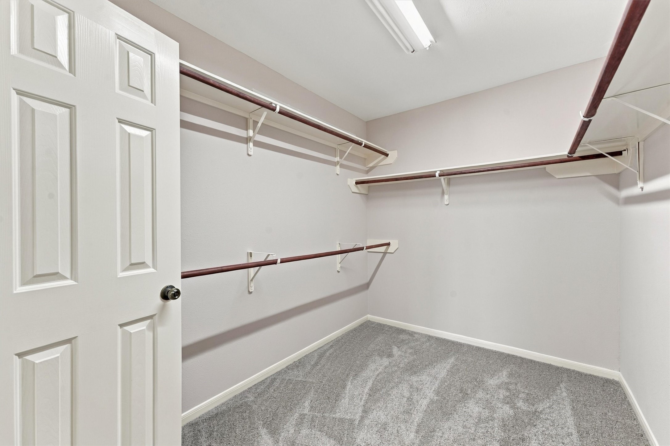 Spacious walk-in closet with ample shelving and hanging space, perfect for organized storage.