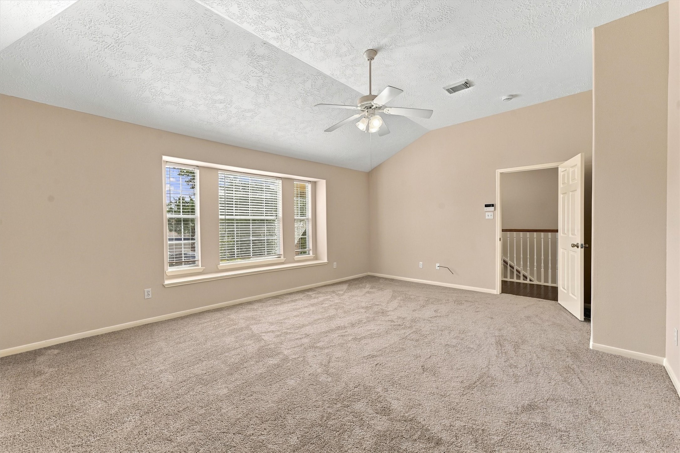 Experience ultimate comfort in this expansive primary bedroom, featuring abundant natural light and a serene atmosphere.