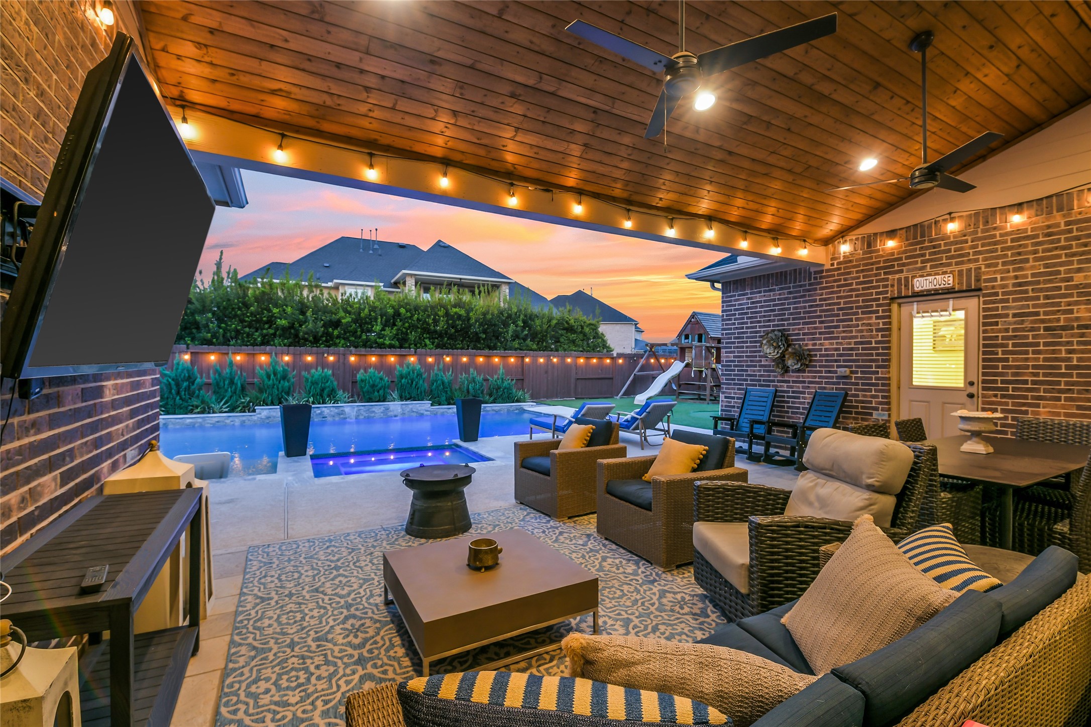 Expansive covered outdoor living area with ample seating, a convenient pool bath, and seamless indoor-outdoor entertaining.