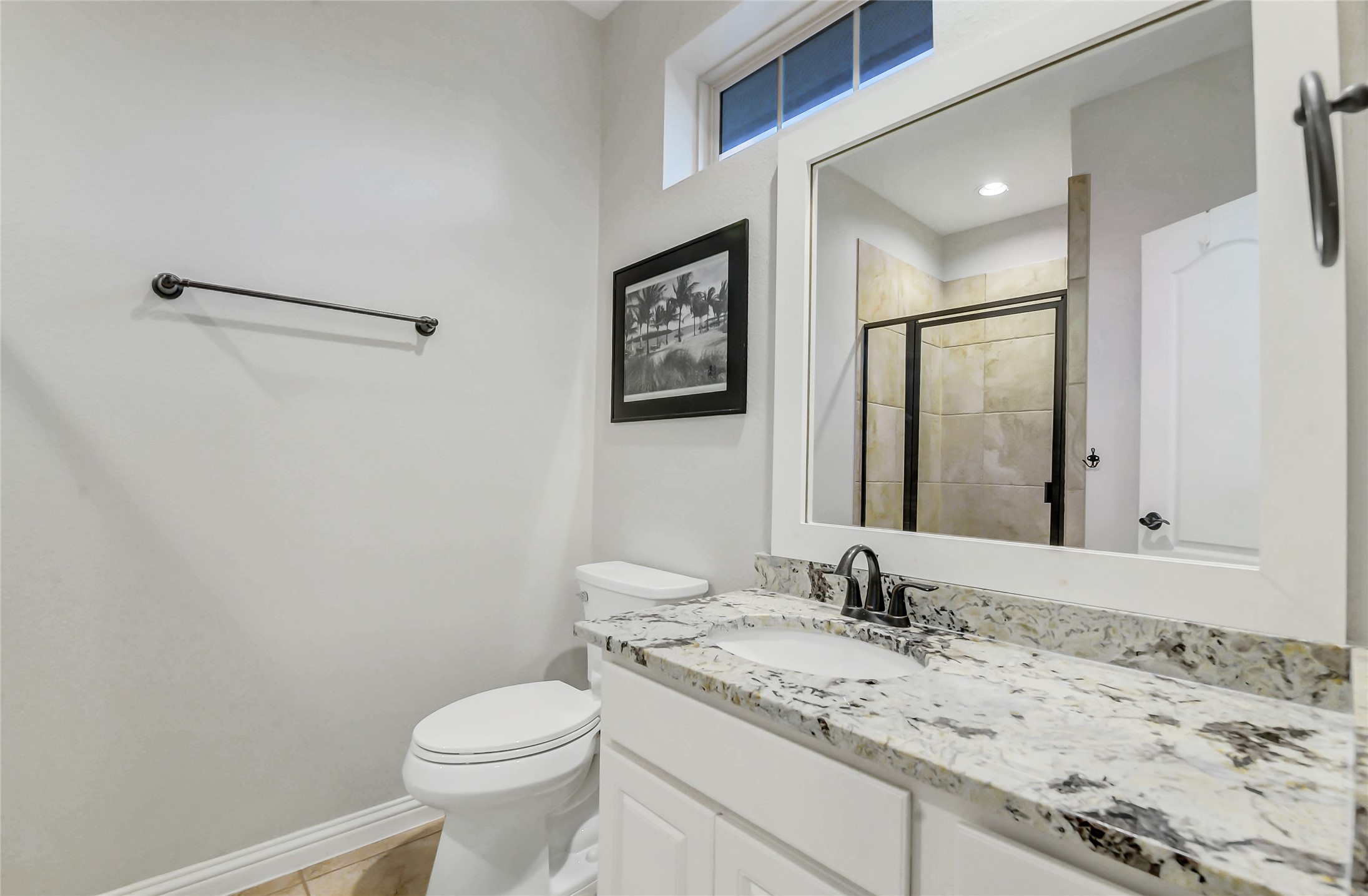 Upstairs ensuite bathroom features a granite vanity, a spacious walk-in shower with tile surround, glass enclosure and elevated finishes.