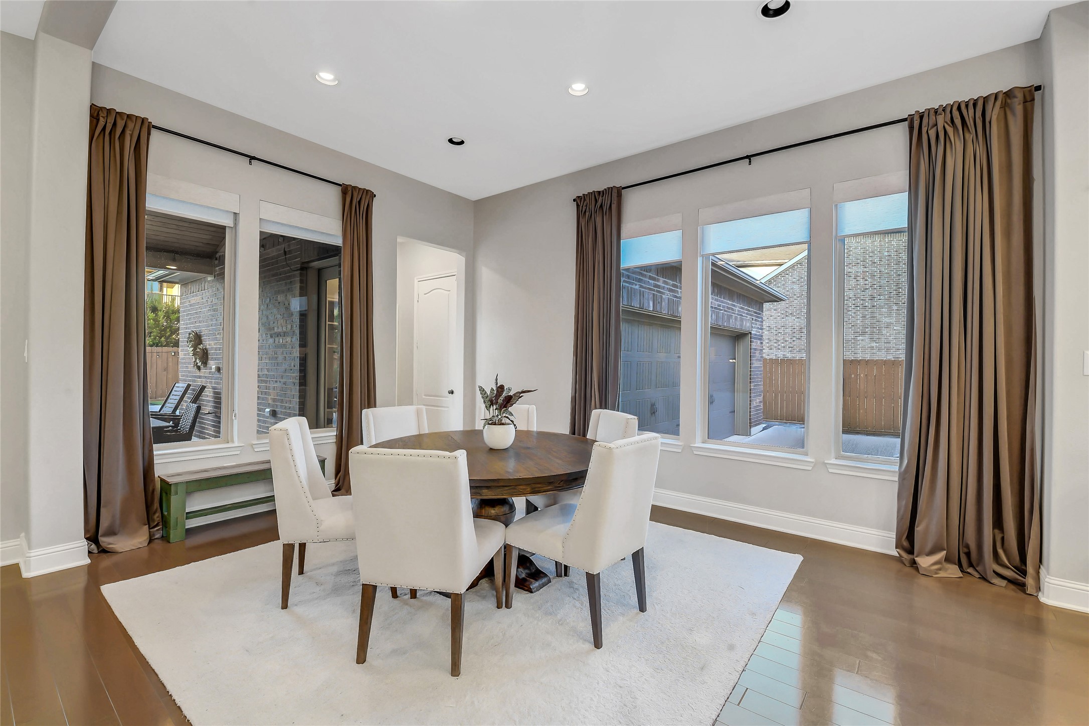 Light-filled breakfast room featuring walls of windows and seamless access to the mudroom, backyard, and attached garage.