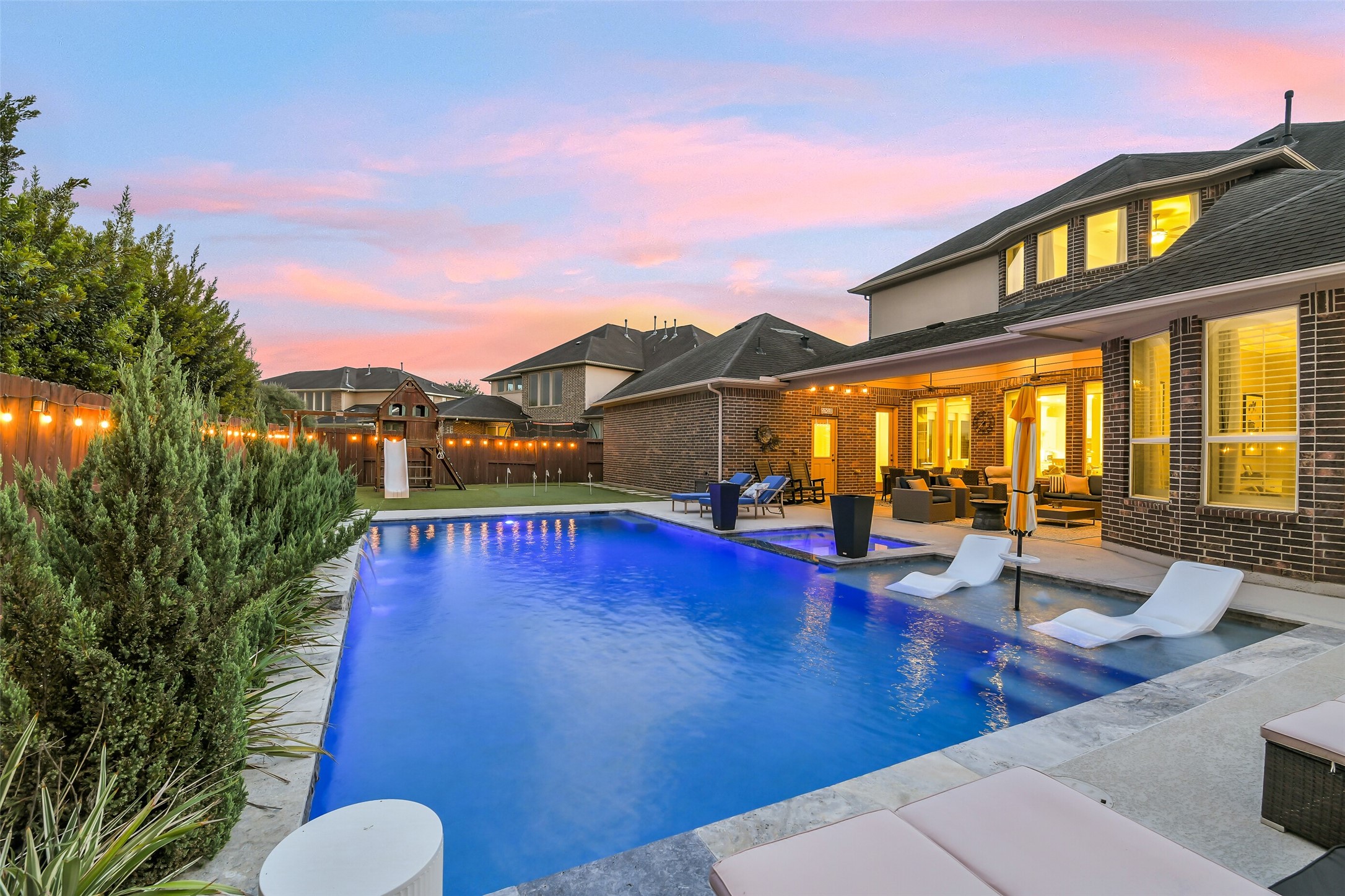 Enjoy resort-style outdoor living with a heated pool/spa, a custom putting green, and additional green space for golf practice, games, and family fun. An expansive covered patio and convenient outdoor pool bath make entertaining and relaxing effortless.