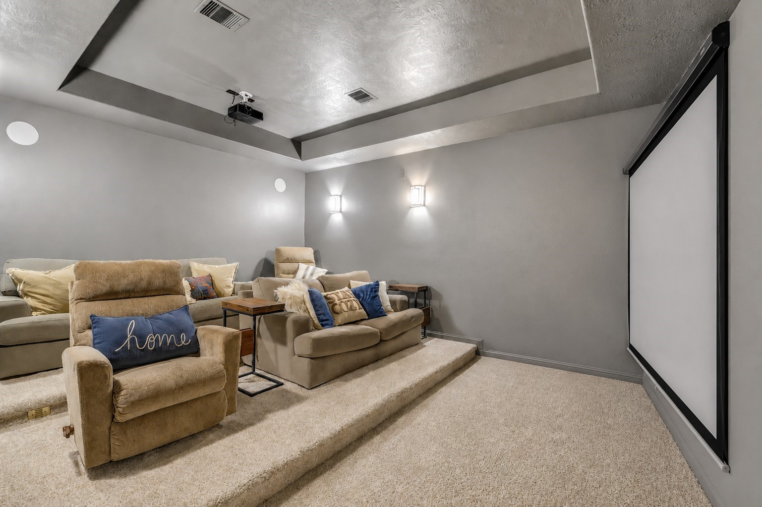 Private media room featuring stadium-style seating, a projector, and a theater screen for an immersive viewing experience