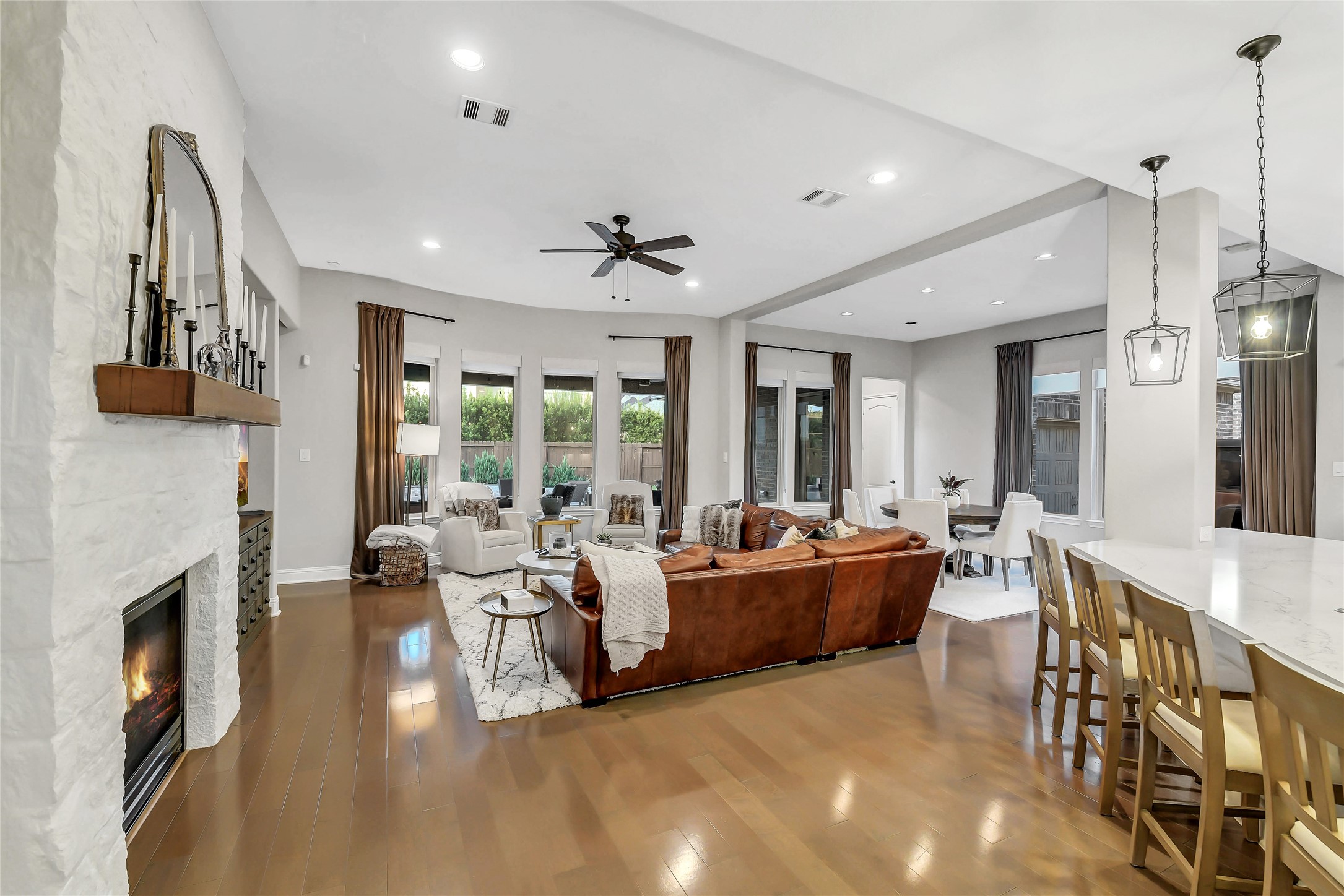 Spacious family room with wall of windows overlooking backyard paradise opens to kitchen and breakfast for seamless entertaining with family and friends. Expansive breakfast bar with pendant lighting seamlessly connect the kitchen to the family room.