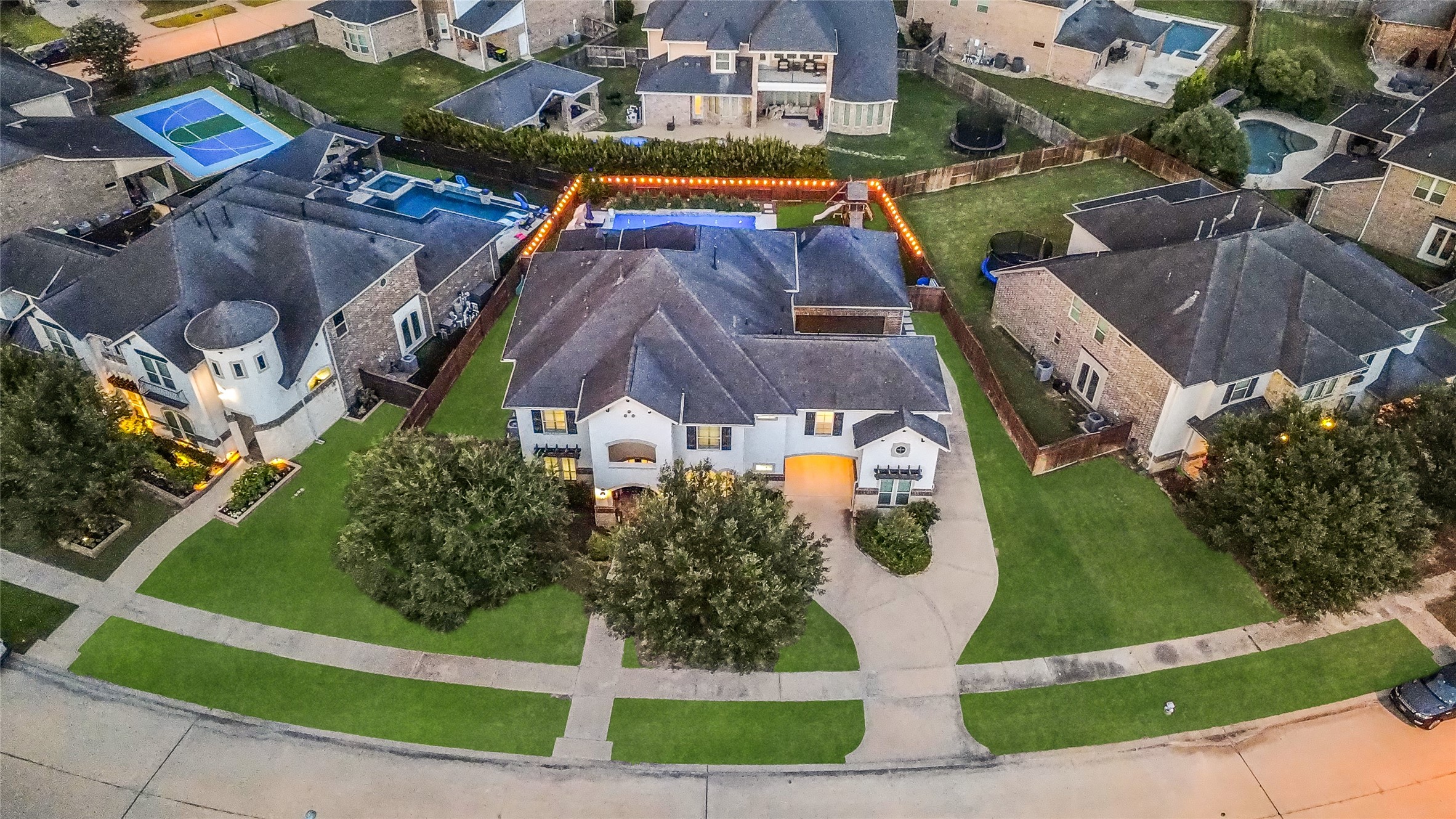 This aerial view highlights the homes impressive curb appeal, oversized lot and private backyard oasis with a pool and covered patio.