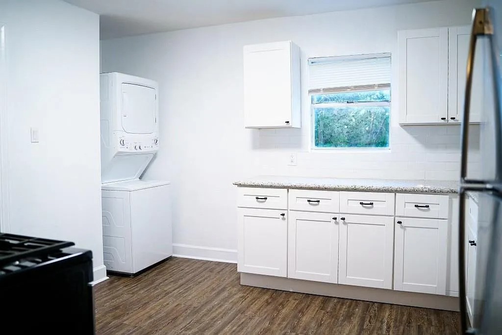 Kitchen with White Cabinets, Granite Countertops, and Stacked Washer/Dryer