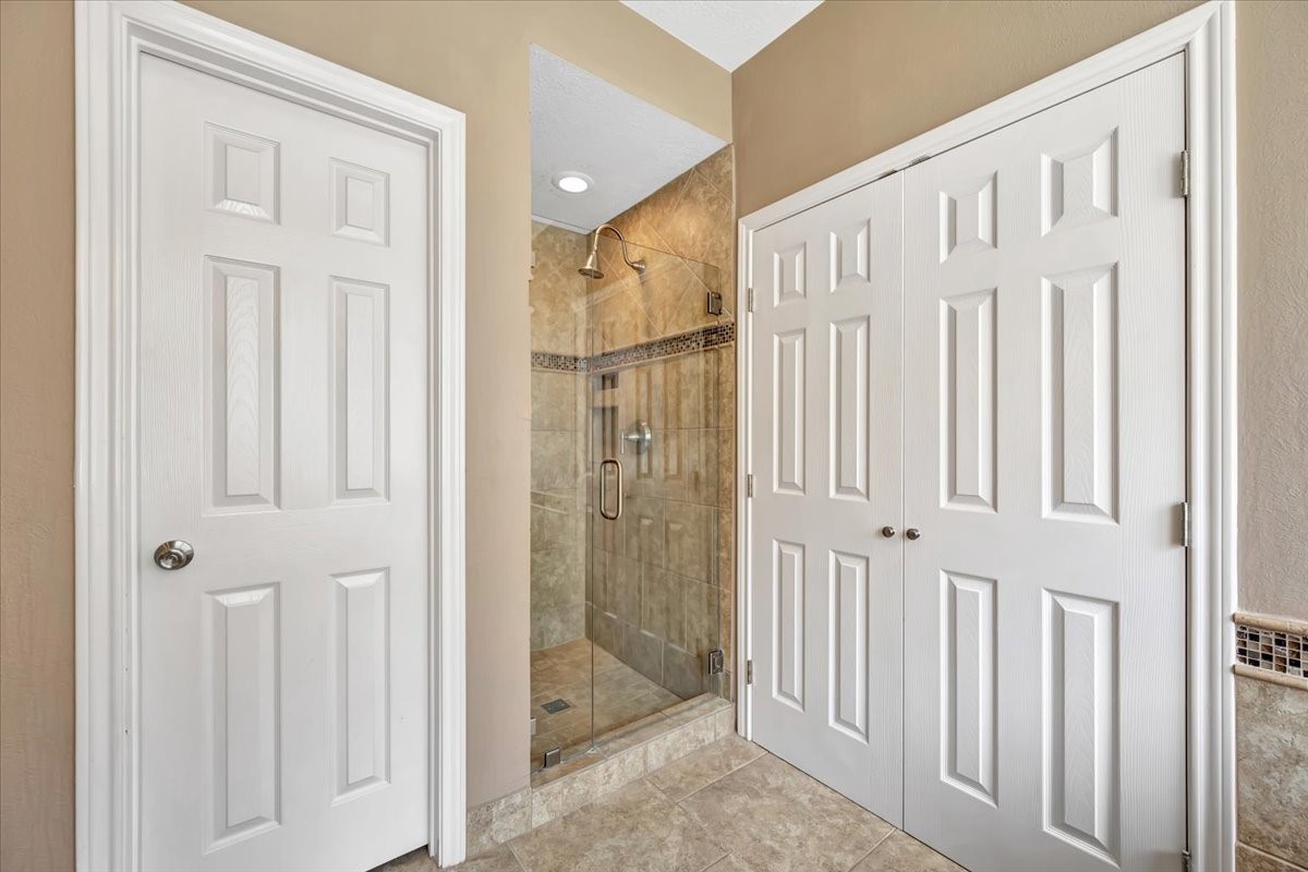 Separate shower and double doors to the walk-in closet on the right.