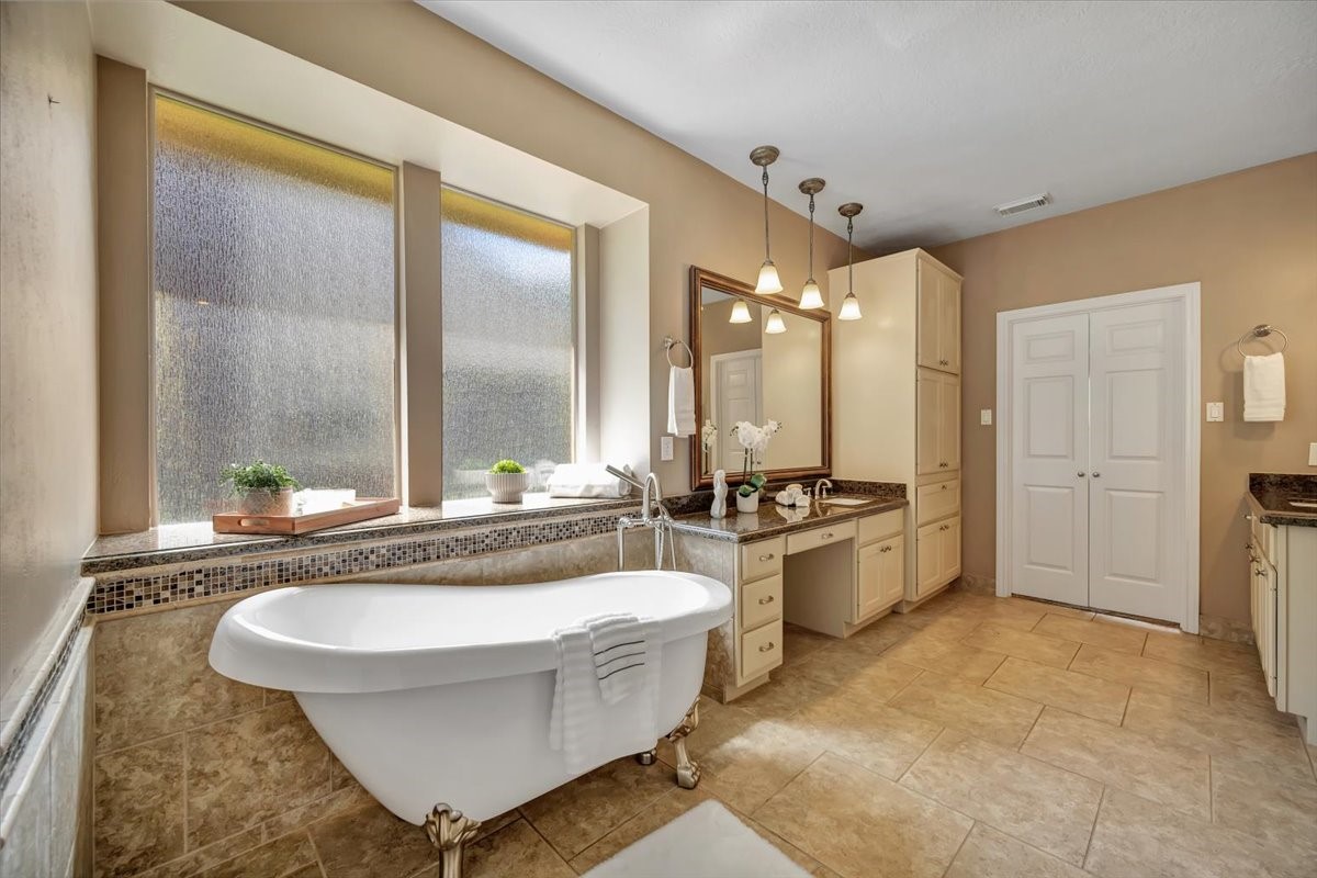 Spacious primary bath with a relaxing claw-foot tub and walk-in shower. .