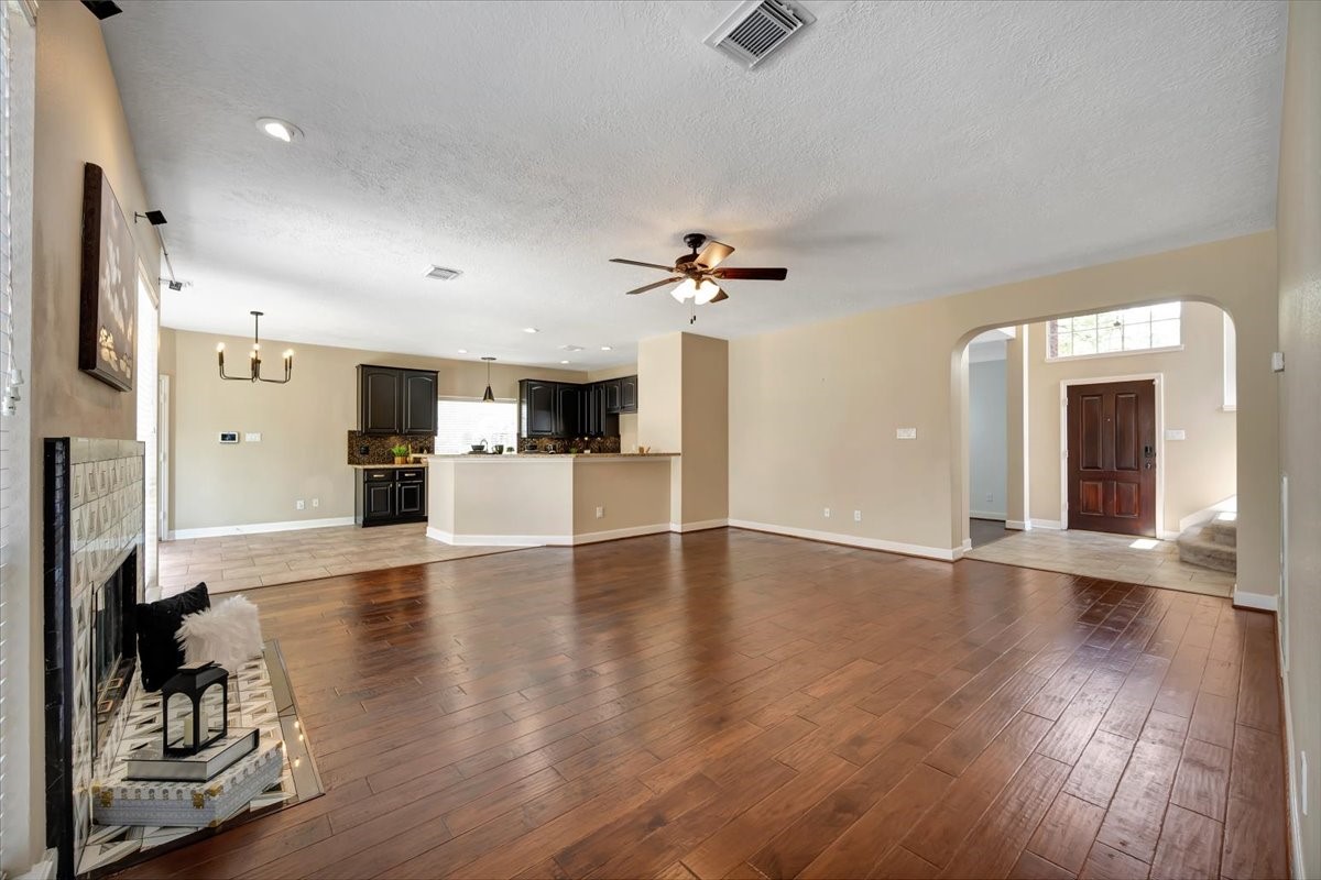 Bright formal living space with warm engineered wood flooring and natural light. Bright formal living space with warm engineered wood flooring and natural light.