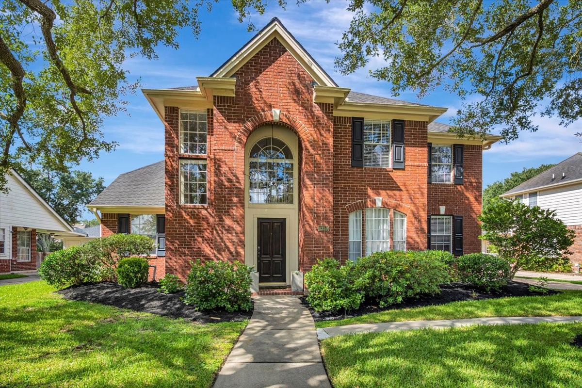 Exterior view showcasing the homes brick elevation and fresh landscaping.