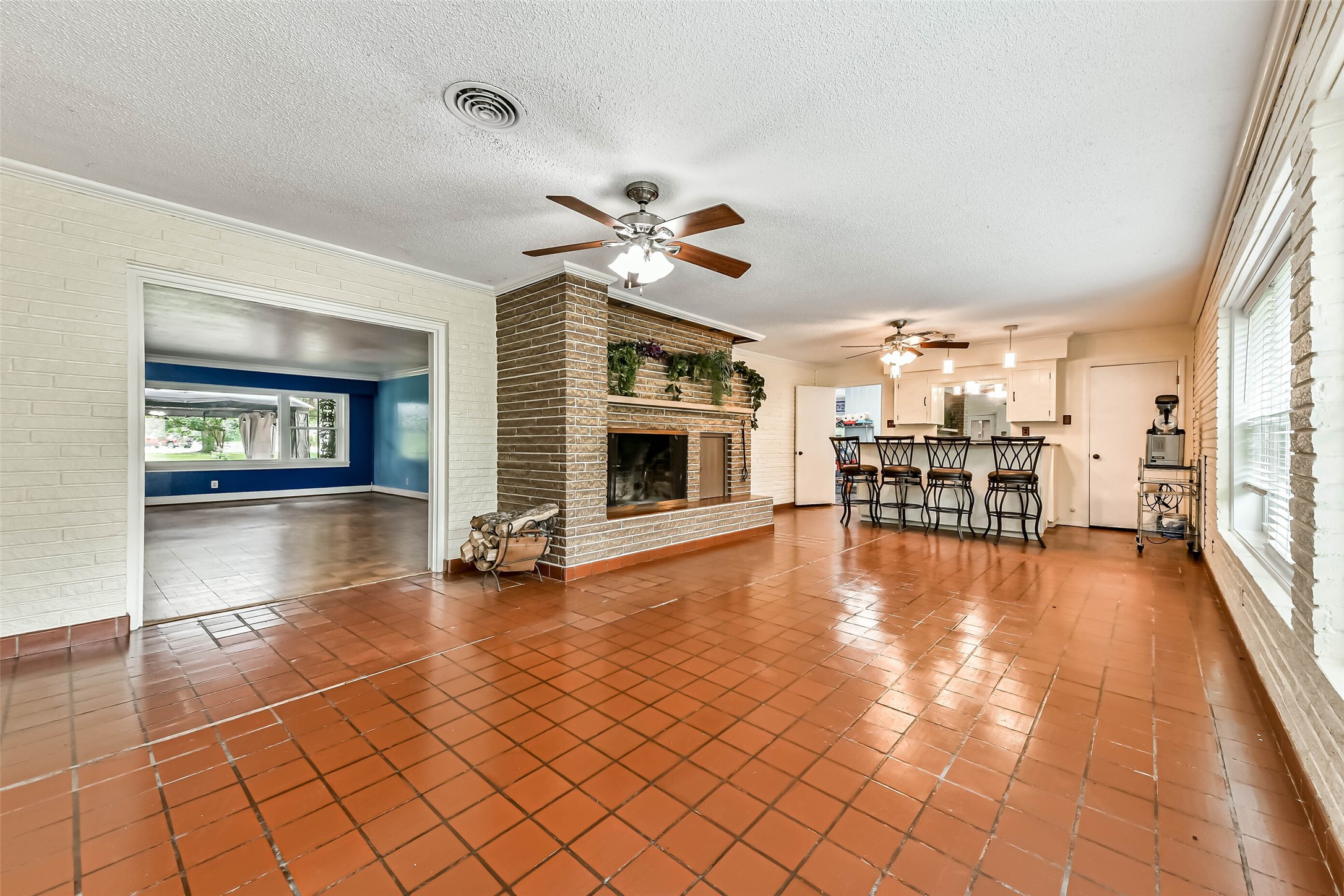 Large Sunroom is the same length as the formal living and dining room.  Brick built-in Fireplace with lighting and a planter.  Bar at the end stays as well as the barstools.  However the seller will be retaining the marguerite machine.  All new windows throughout the home