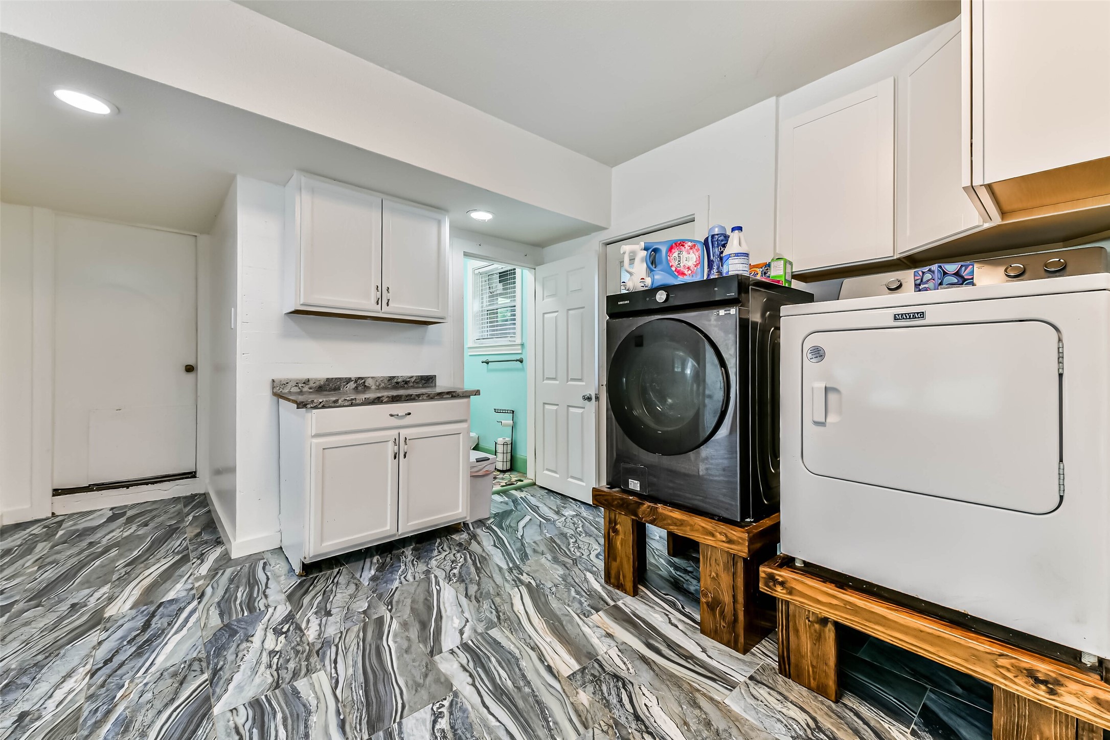 Cabinet area for a microwave or coffee pot with storage.  Washer dryer located in the garage conversion.  Door left of dryer is the full bath for the garage conversion.