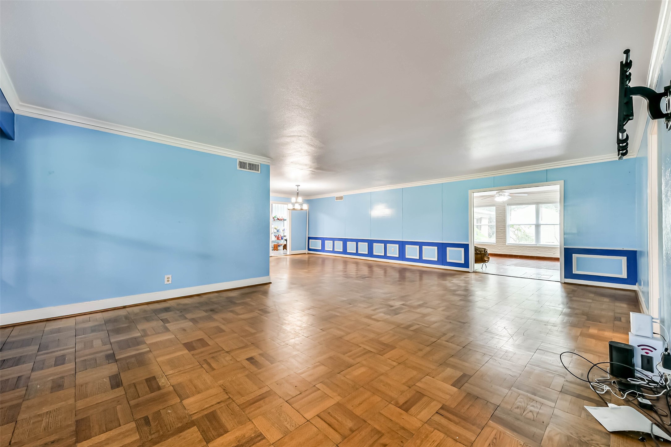 Entering the formal living and dining, standing in large entry way.  Beautiful Parquet flooring.