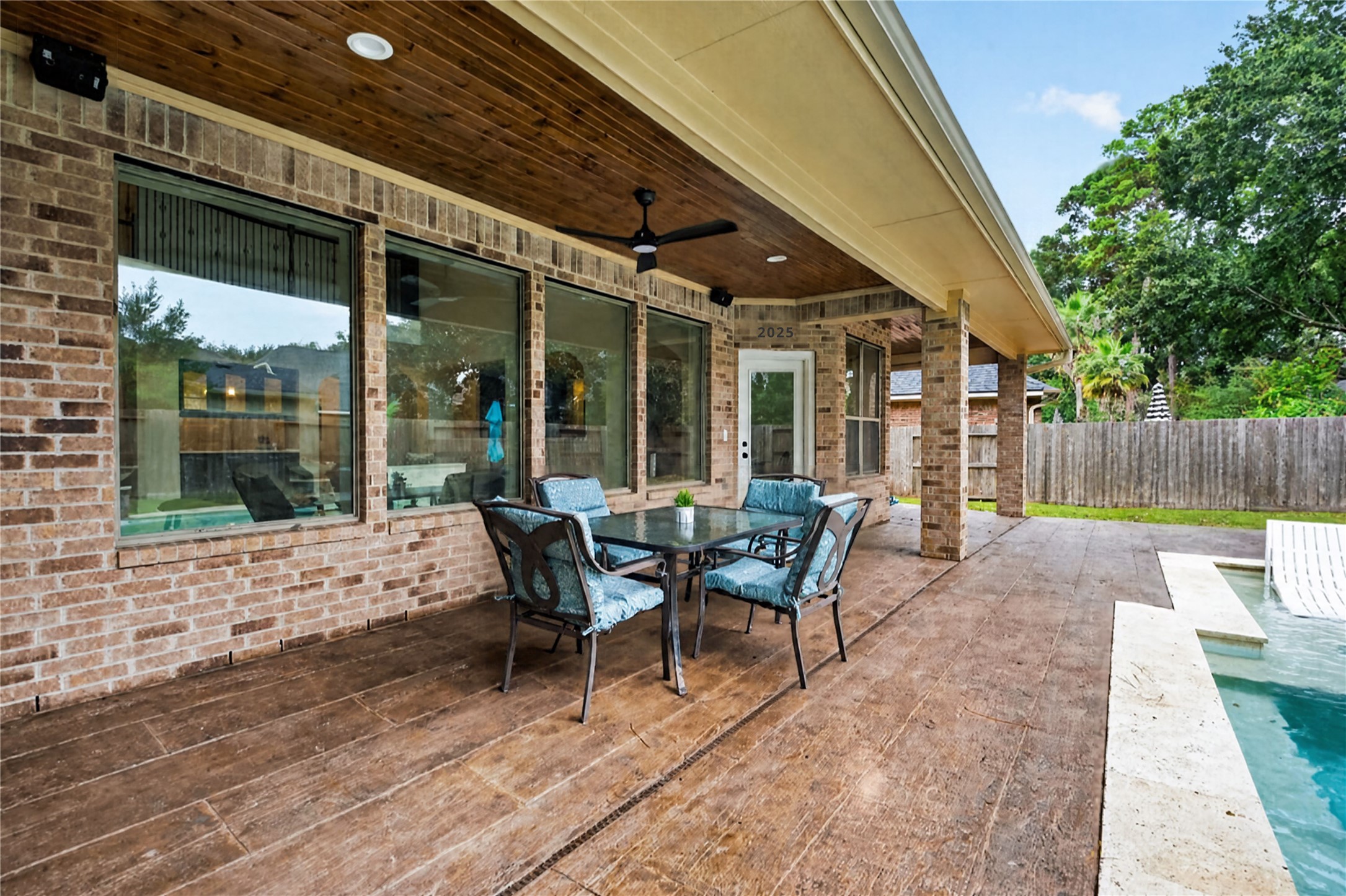 Custom covered back patio with tile flooring makes for easy cleaning & fun entertaining year-round.
