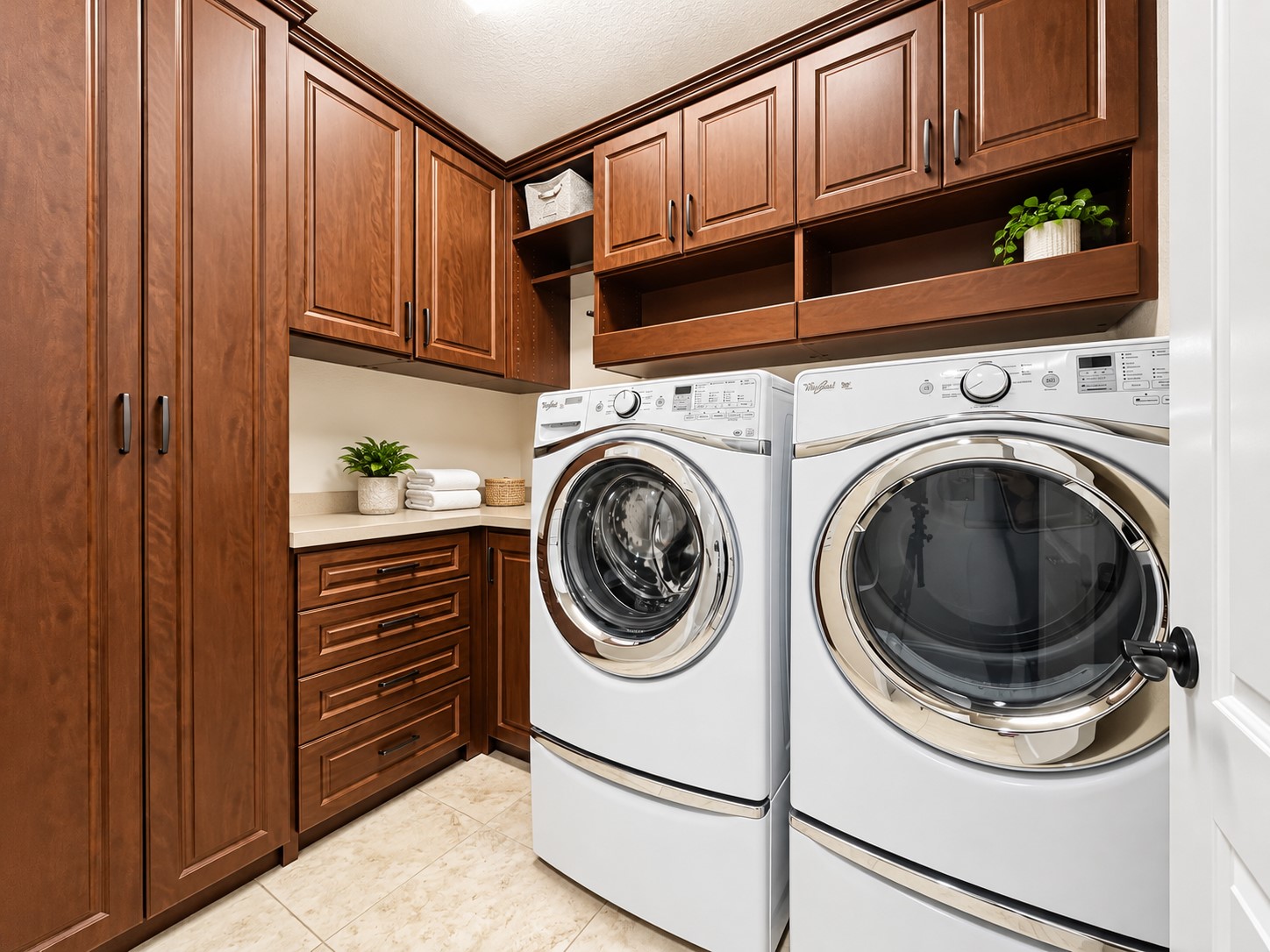 Enjoy a dedicated utility space with custom cabinets and drawers that provide practical storage while keeping everyday essentials neatly tucked away. Custom built-in cabinets and drawers offer convenient storage for laundry supplies, household essentials, and everyday items.