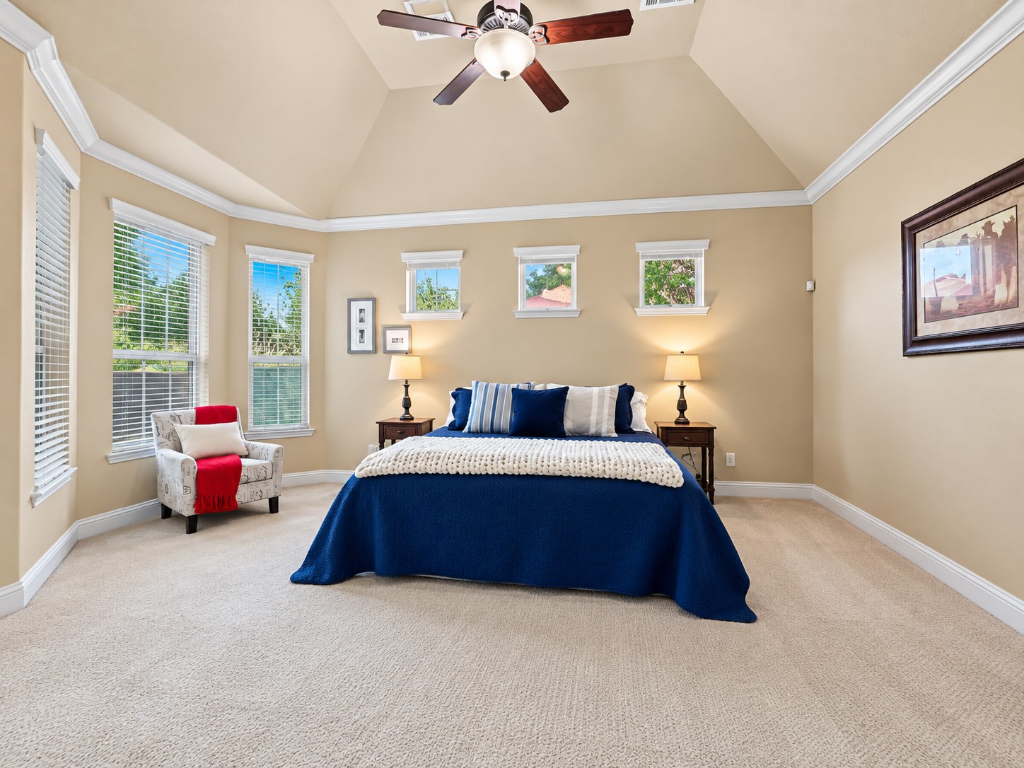 High ceilings and tall windows give the primary suite an open feel, while natural light creates a relaxing atmosphere.