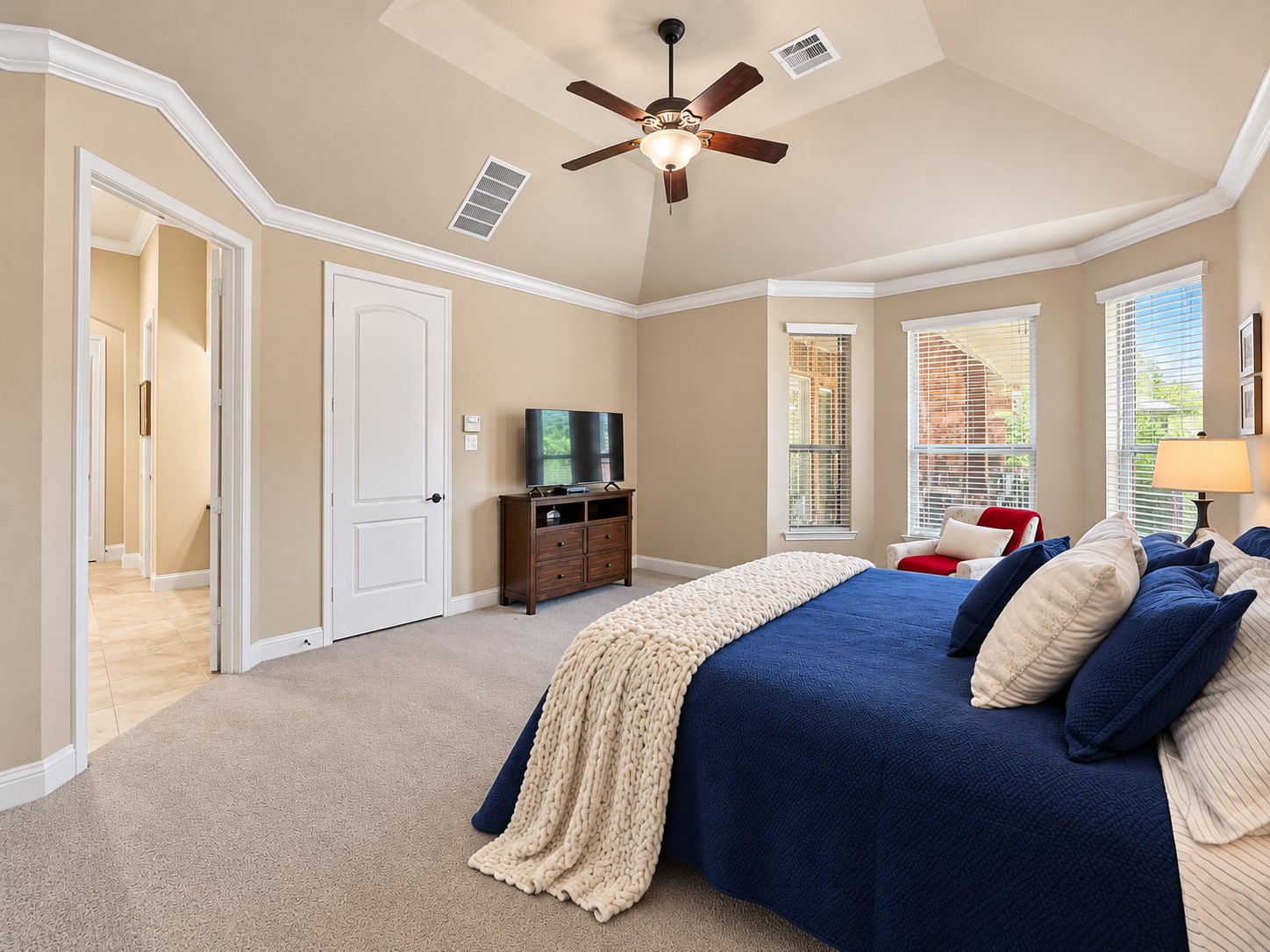 A private place to begin your morning and wind down at night, the primary suite offers a comfortable escape from the day's busy schedule. High ceilings enhance the open feel of the primary bedroom, while multiple windows bring in natural light.