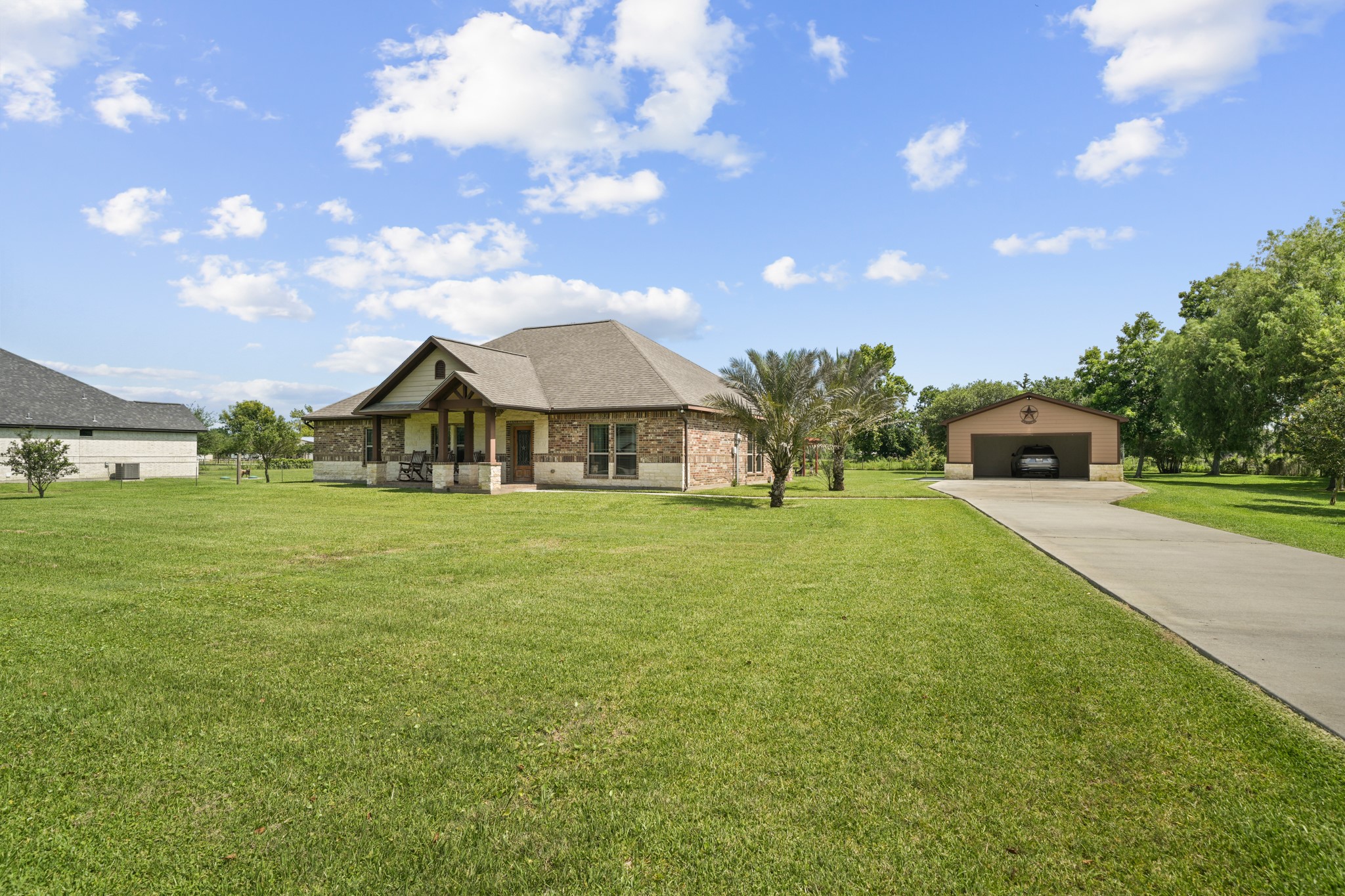 Experience serene country living with a charming front porch featuring inviting rocking chairs and elegant stone column details.