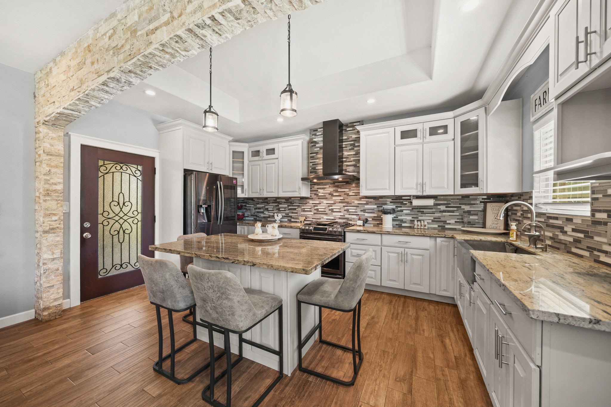 Kitchen Island: Highlights the granite seating area and the front door context