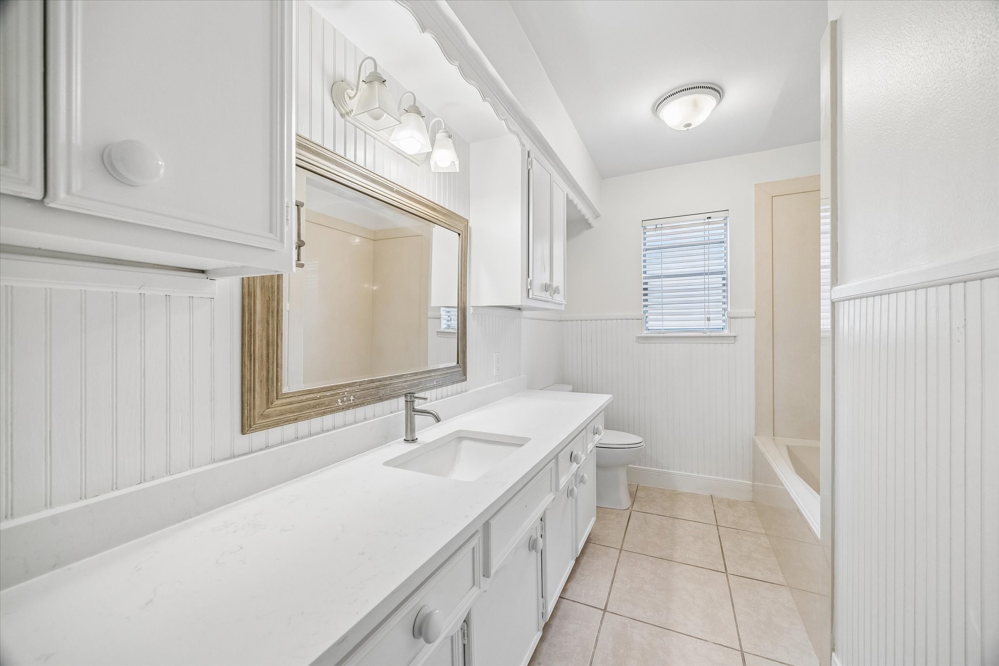 Look how large this secondary bathroom is with new quartz countertops.