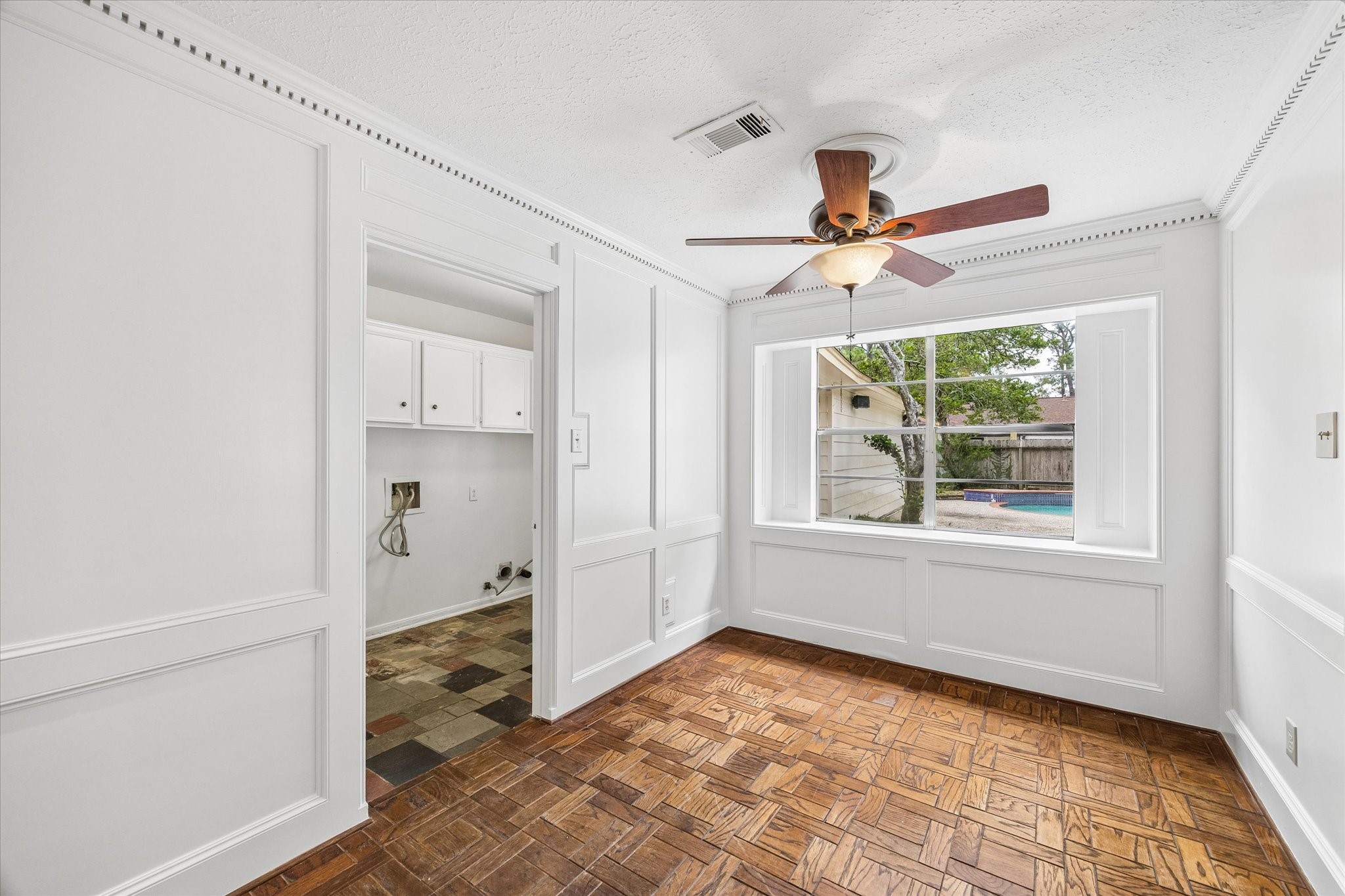 The large windows in the breakfast room overlook the pool.