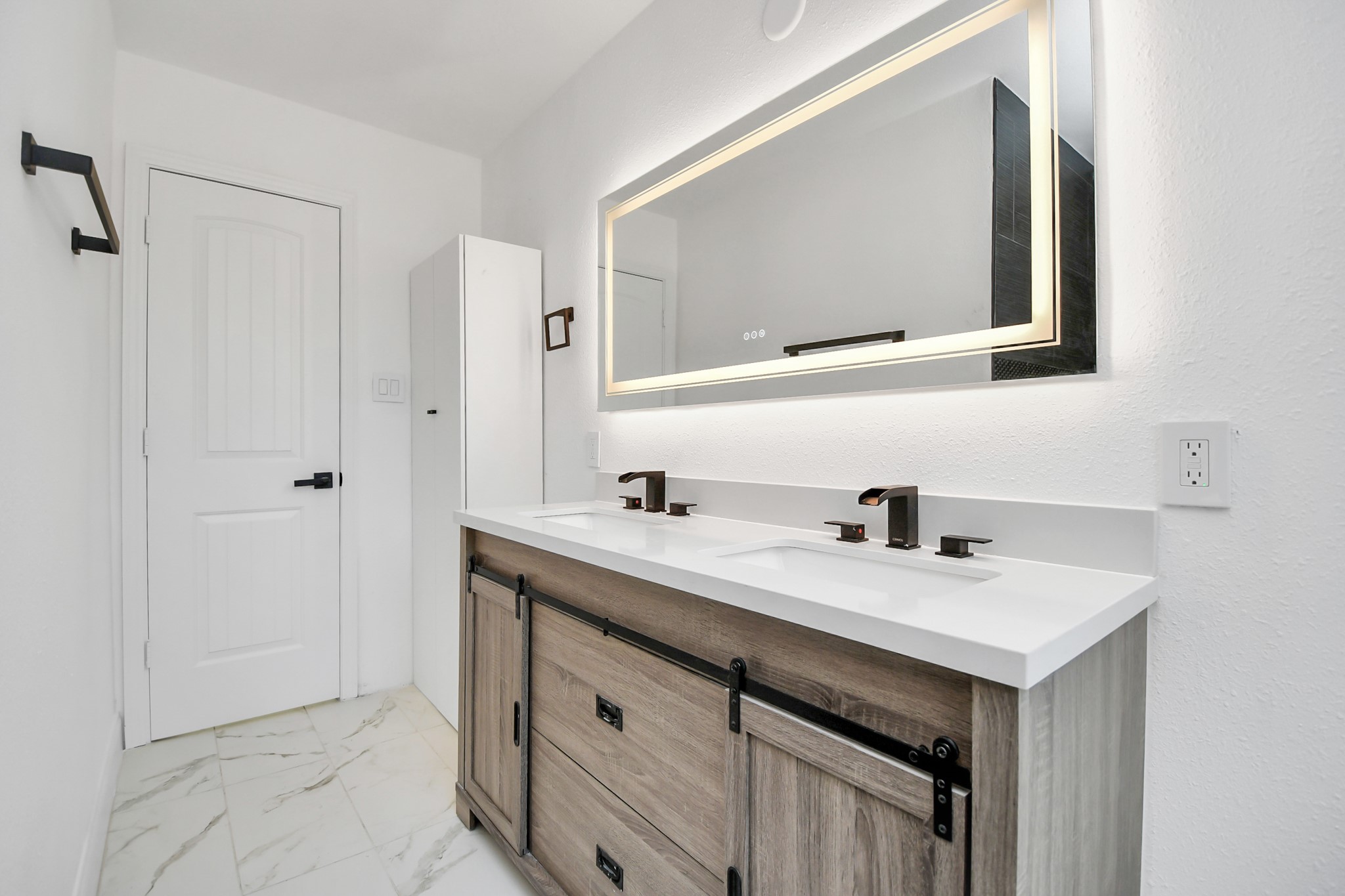 Another updated bathroom upstairs features a smart mirror and dual sinks.