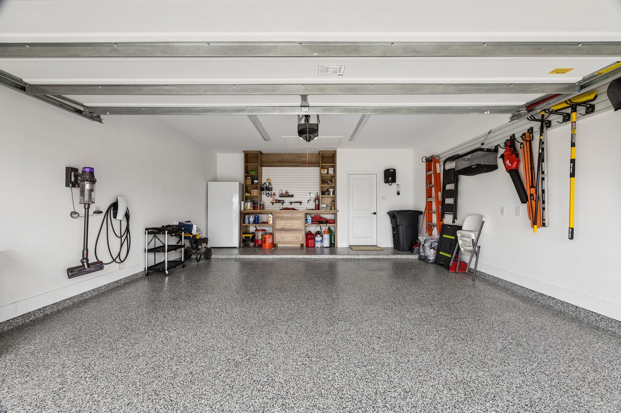 The ulimate garage upgrade features epoxy-coated floors, a solid wood workbench, slat-wall storage orgainzation, and ample space for projects, hobbies and vehicles.