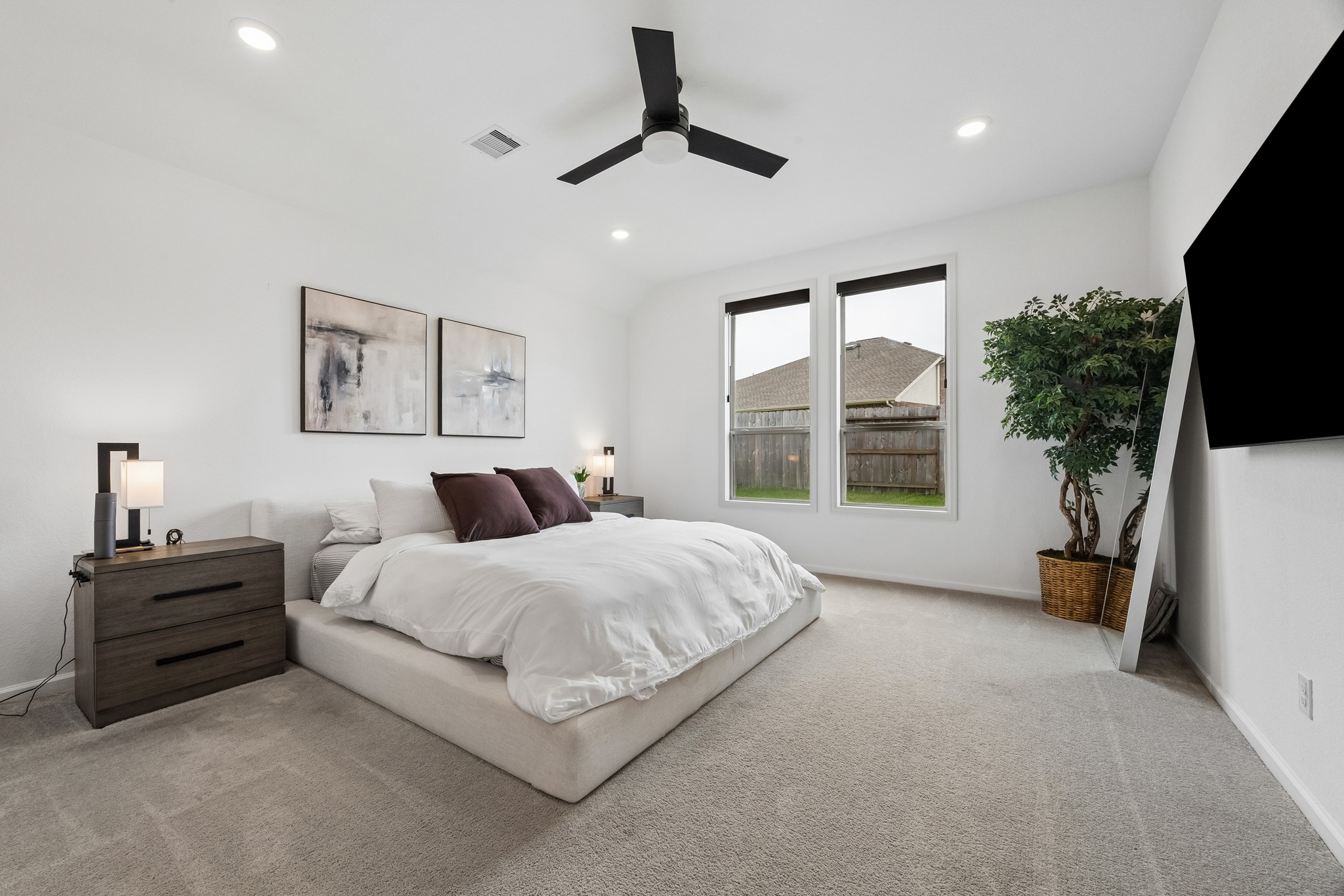 The primary bedroom is oversized with plenty of natural light and storage. The upgraded fan and automatic window shades make for a calm and comfortable retreat.