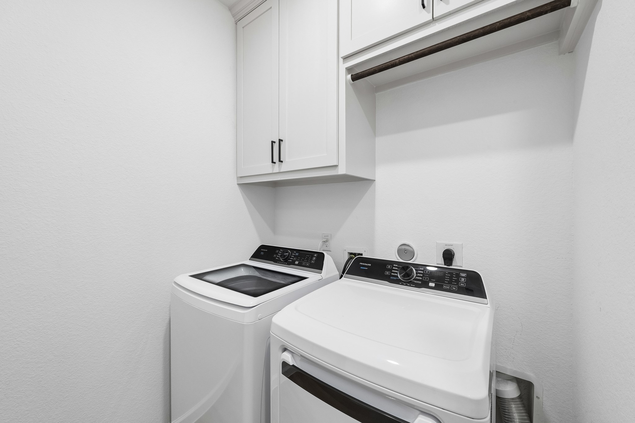 Laundry room had built-in cabinets added along with hanging rod for ease of use on laundry day.