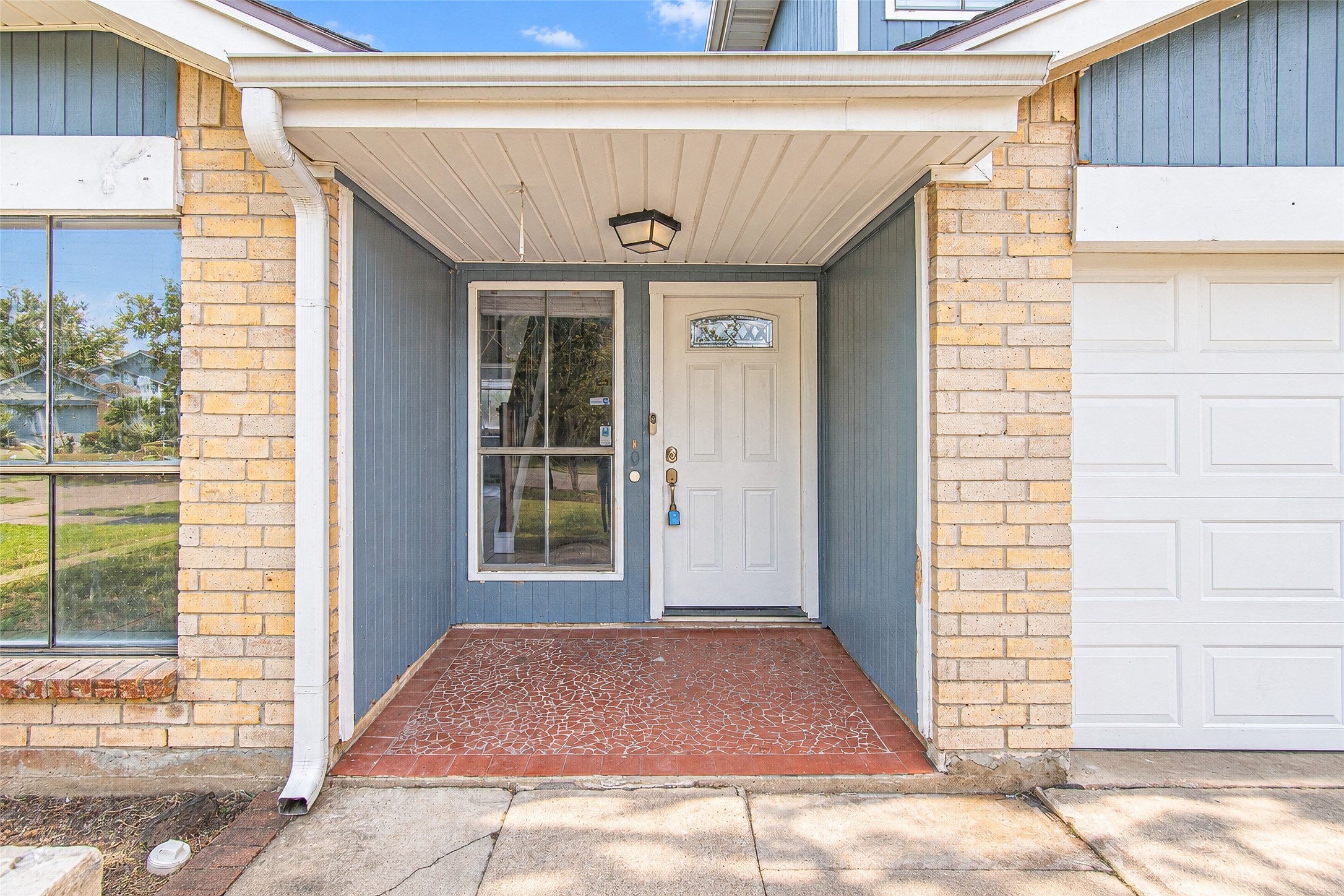 Charming entryway featuring a covered porch with a modern white door and brick accents, offering a welcoming first impression. Charming entryway featuring a covered porch with a modern white door and brick accents, offering a welcoming first impression.