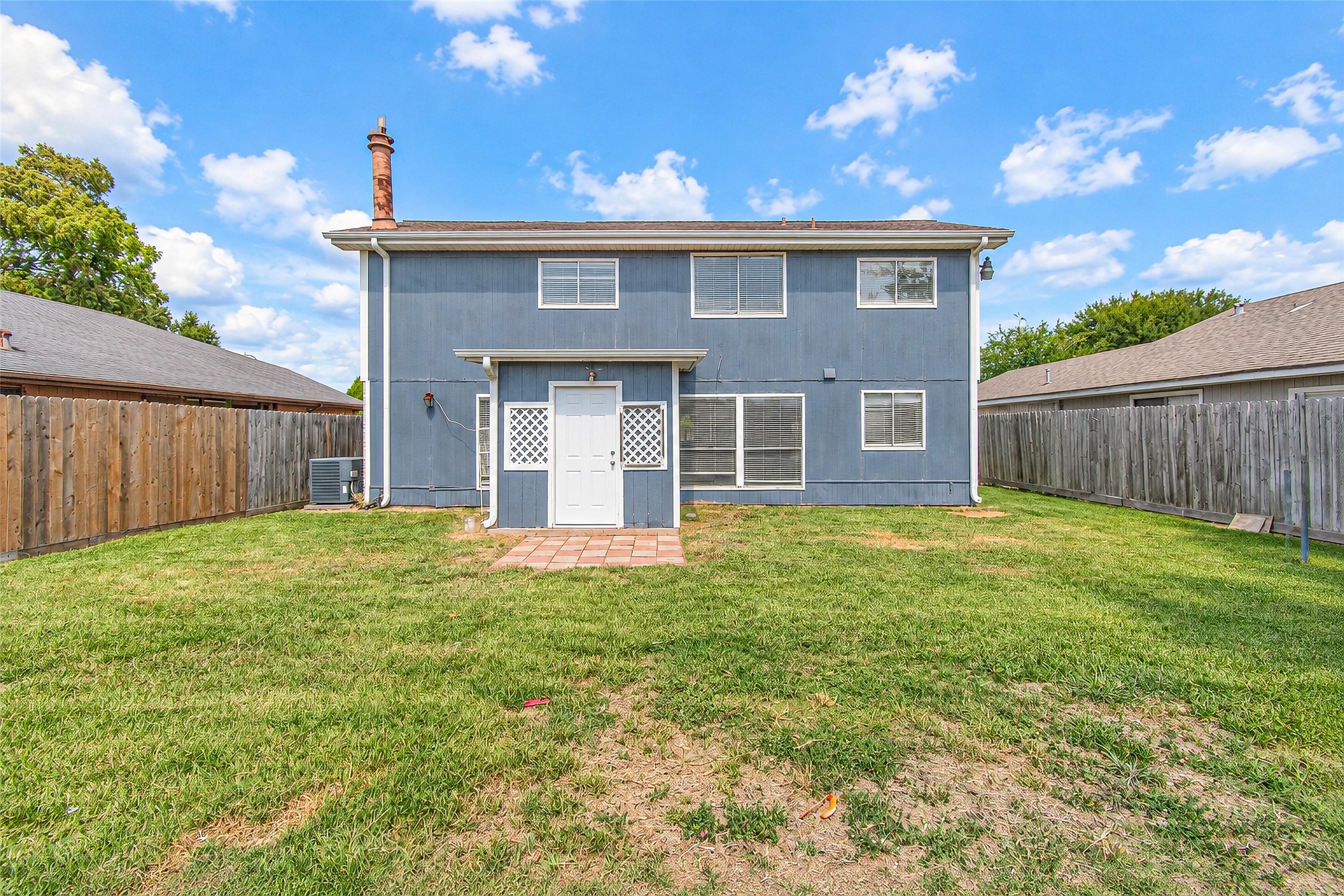 Charming two-story home with a spacious, fenced backyard, perfect for outdoor activities and gatherings.