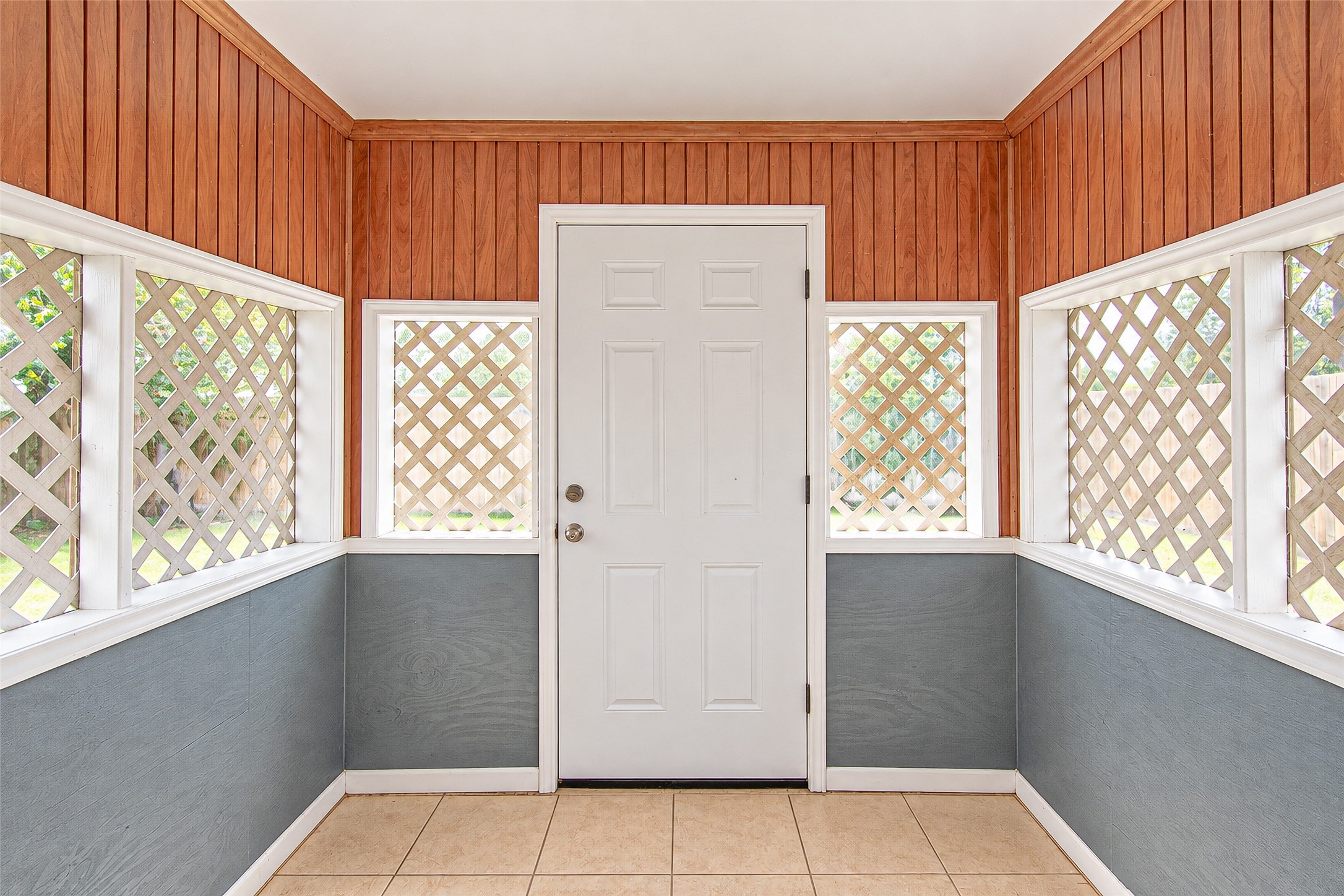 Charming entryway with warm wood paneling and lattice windows, creating an inviting and cozy atmosphere.