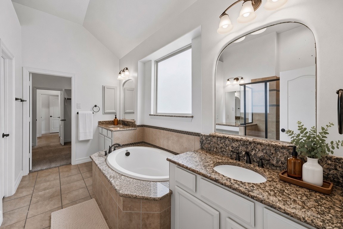 virtually staged - primary bath is stunning with it's symmetry, double vanities, large tub, separate shower, make up nook and access to huge walk in closet