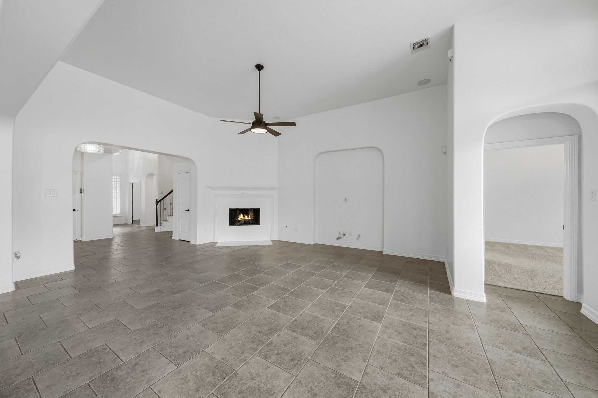 another view of the living room showing the fireplace and primary hallway