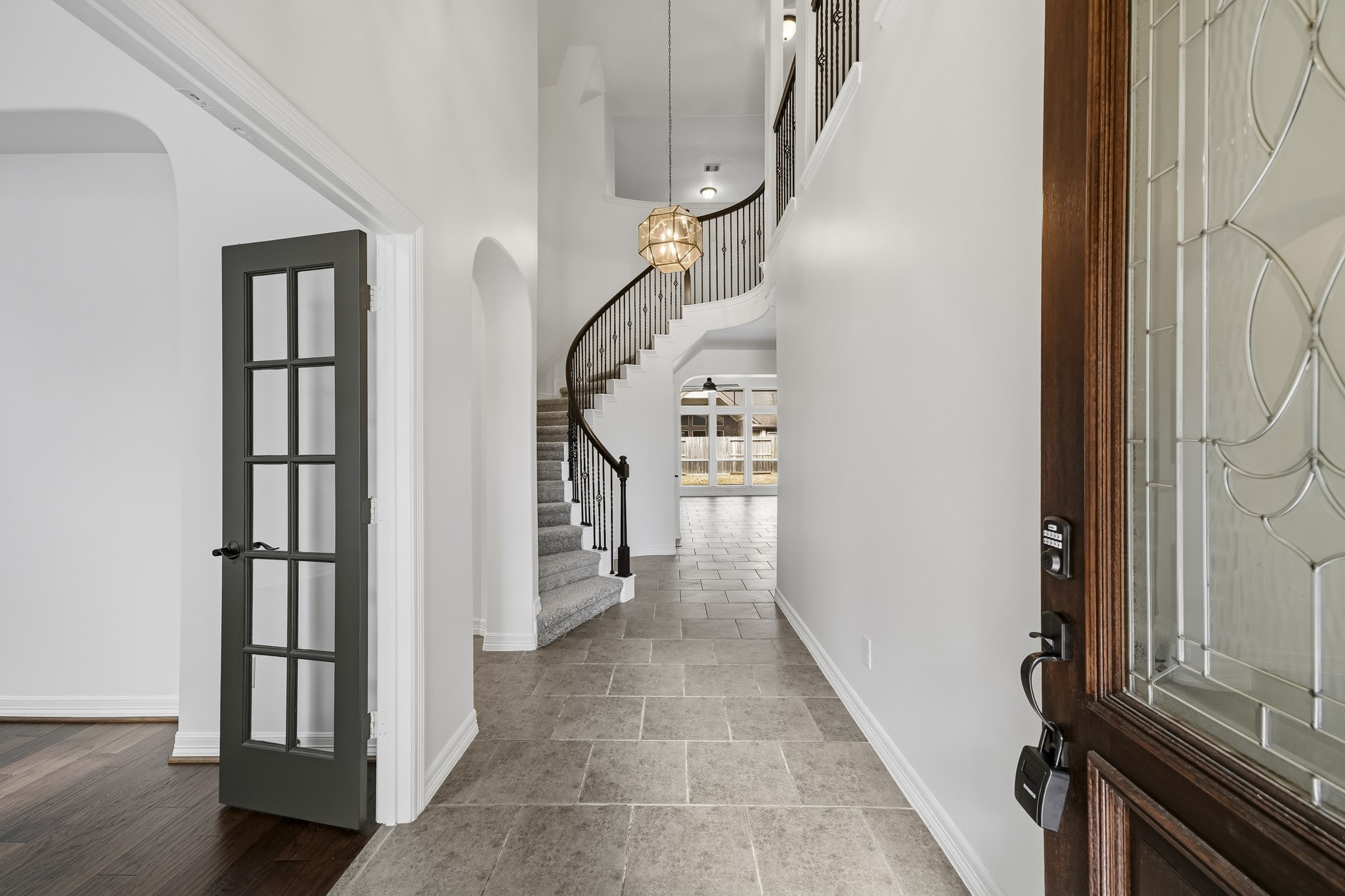 Inviting entry with study to left, tall ceilings and stunning spiral staircase Inviting entry with study to left, tall ceilings and stunning spiral staircase