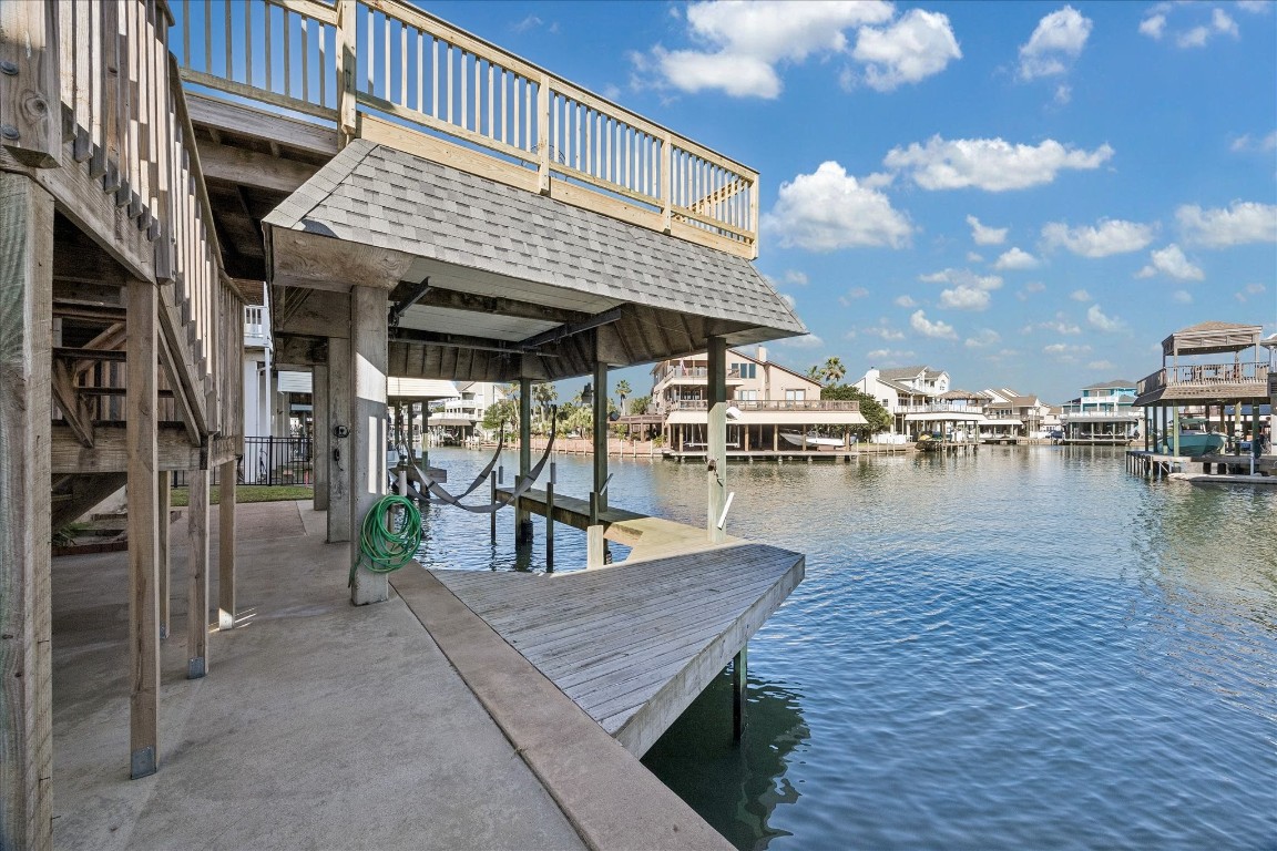 This waterfront property features a sturdy dock with a boat lift, offering direct access to a scenic canal. Ideal for boating enthusiasts, the area is surrounded by charming homes and has a peaceful, picturesque setting.